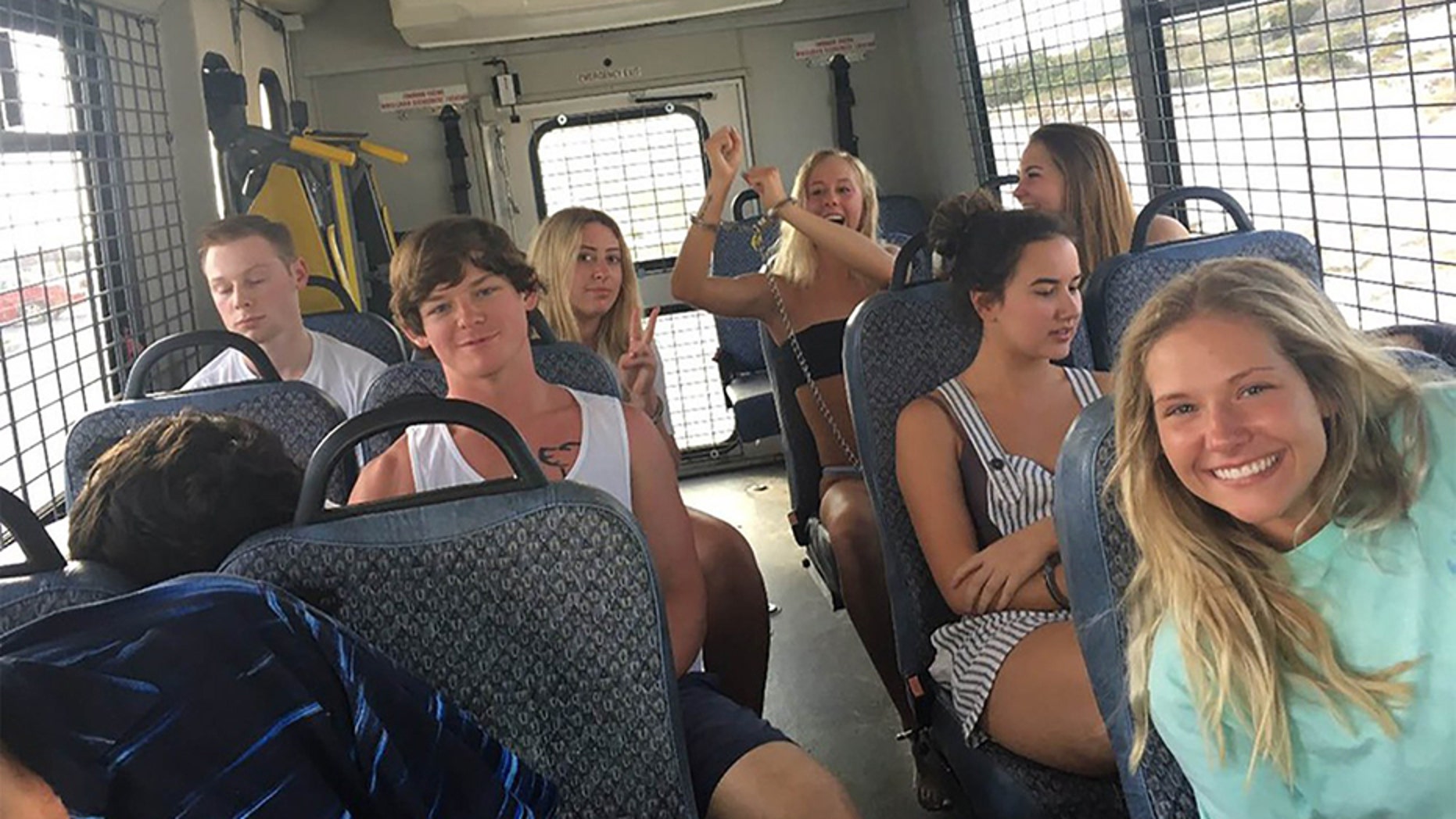 A bus full of 14 underage drinkers posed for the camera on their way to jail.