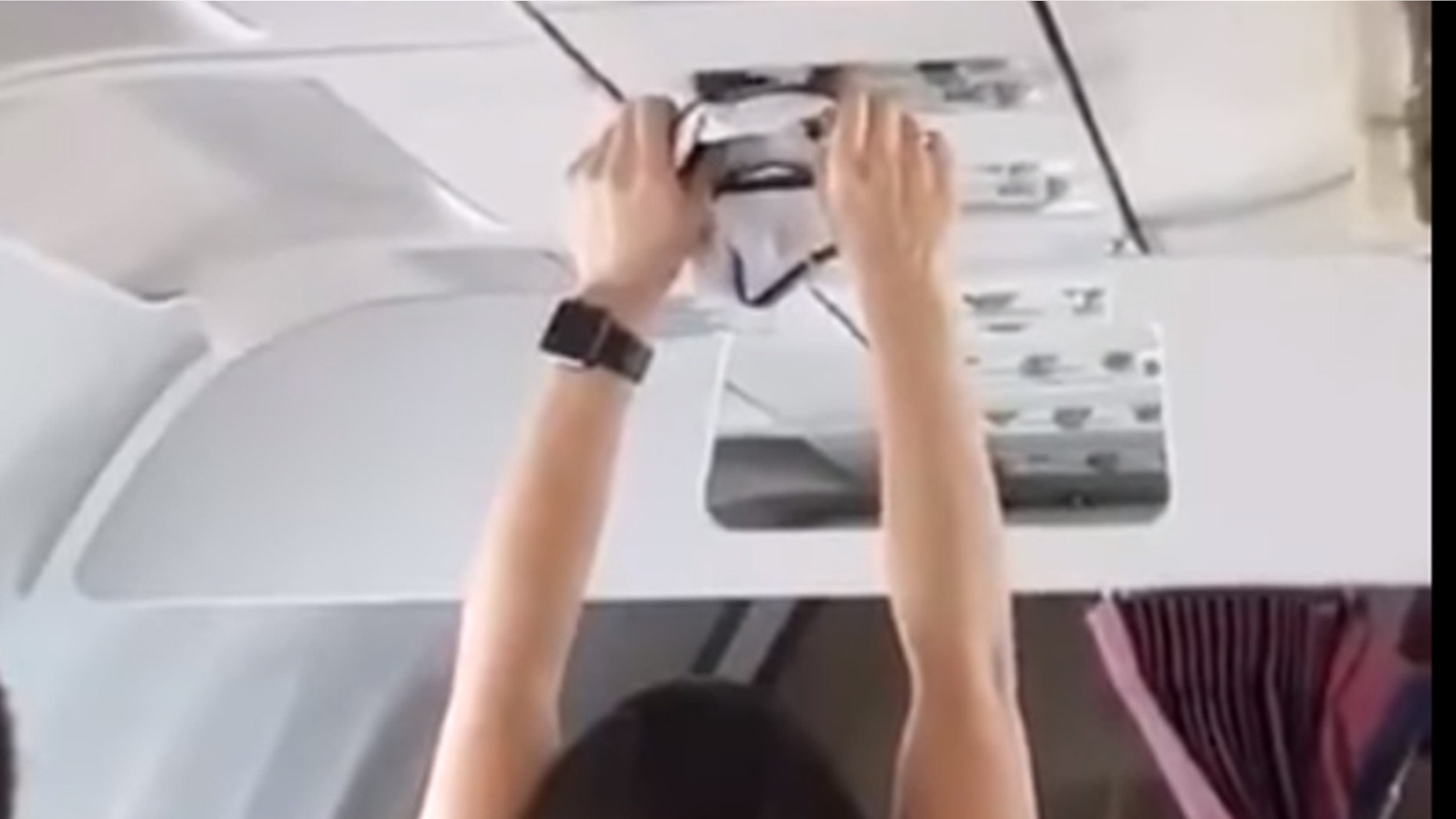 A woman on a flight from Turfy to Russia was caught on video drying a pair of underwear with the overhead vent.