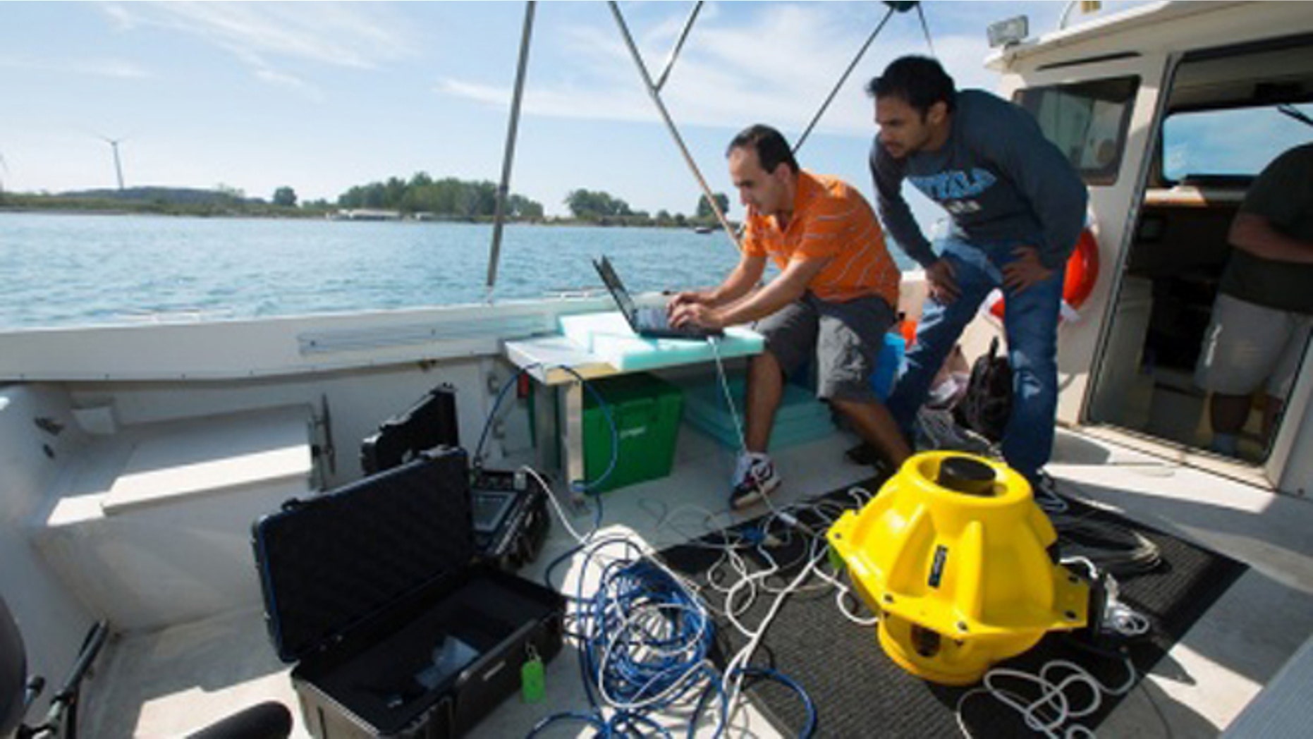 Doctoral candidates with the University of Buffalo drop two 40-pound sensors into the water to test out an "underwater Internet" using sonar rather than radio waves.