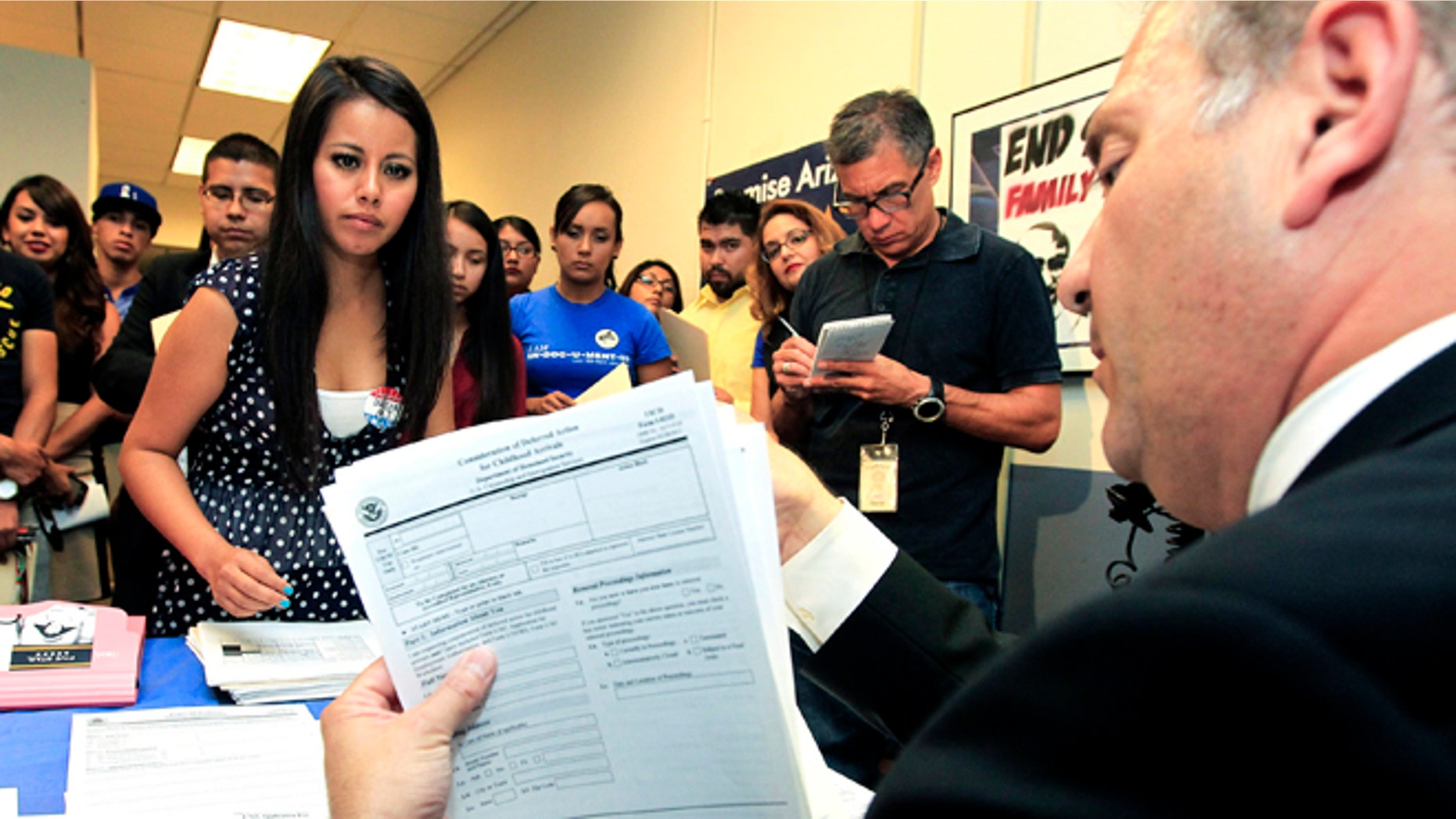 This Aug. 15, 2012 photo shows, Young immigrants, including Gaby Perez, left, hands over all her paperwork to get guidance from immigration attorney Jose Penalosa, right, for a new federal program, called Deferred Action, that would help them avoid deportation in Phoenix. Schools and consulates have been flooded with requests for documents after President Barack Obama announced a new program allowing young illegal immigrants to apply for two-year renewable work permits. (AP Photo/Ross D. Franklin)