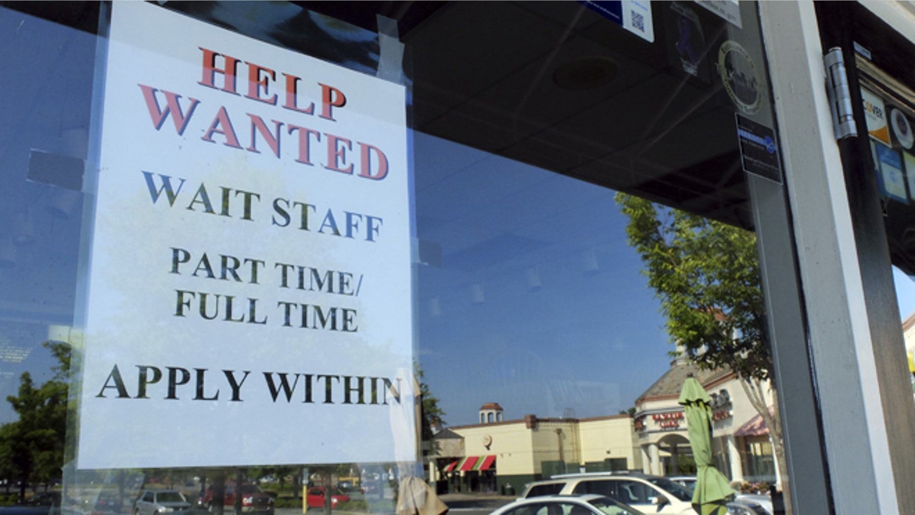 In this , Friday, June 21, 2013, photo, a Help Wanted sign is displayed in the window of a restaurant at a shopping center in Charlotte, N.C. The Labor Department reports on the number of Americans who applied for unemployment benefits last week on July 11, 2013. (AP Photo/Chuck Burton)