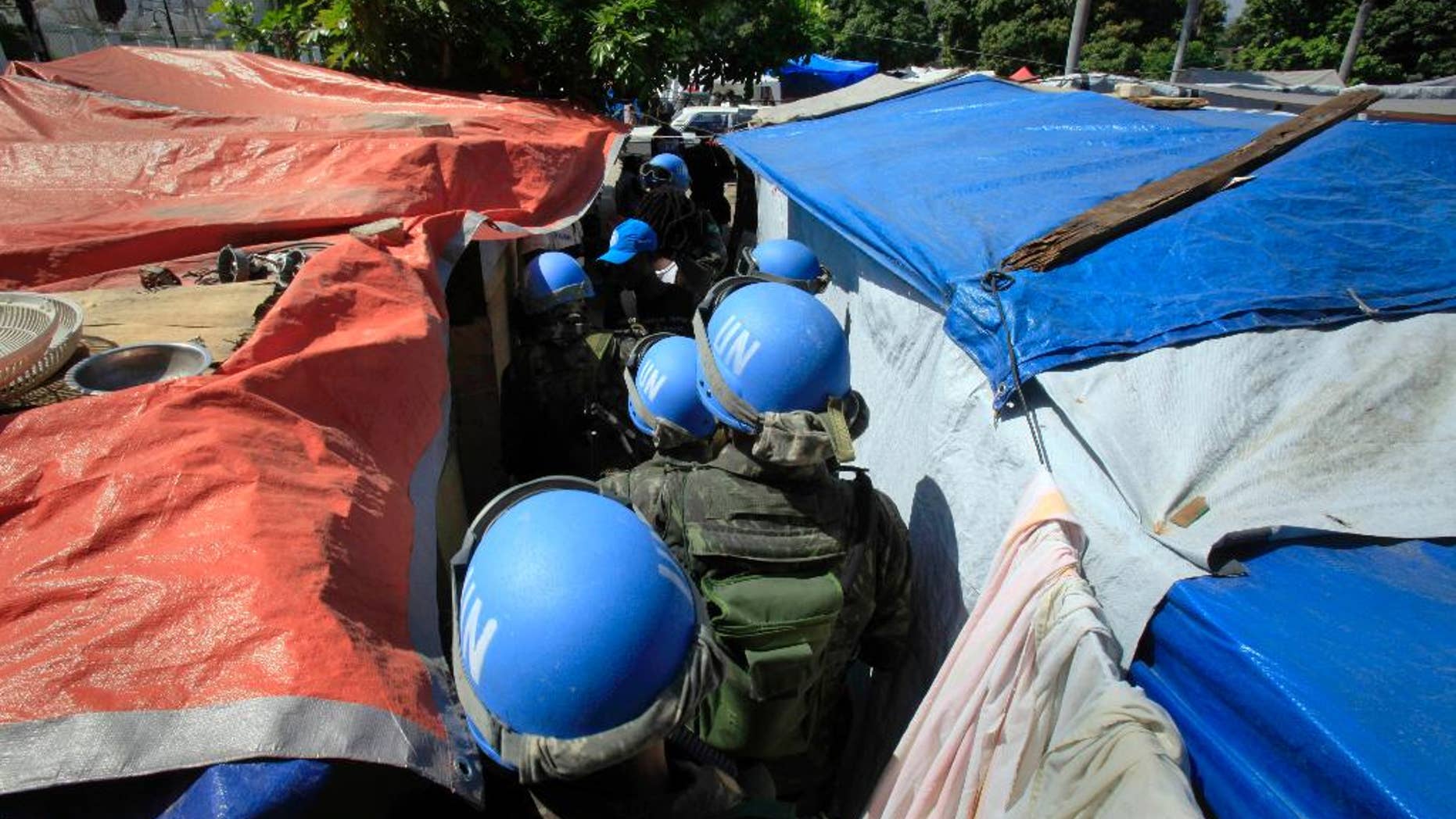 FILE - In this Tuesday, March 30, 2010 file photo, United Nations peacekeepers patrol an earthquake survivors makeshift camp in Port-au-Prince. In 2015, troubled by peacekeepers' sexual relationships with the people they are meant to protect, the UN has quietly started helping with DNA collection to prove paternity claims for so-called "peacekeeper babies." (AP Photo/Jorge Saenz)