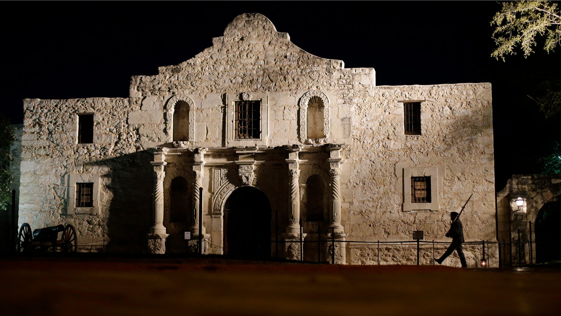 FILE - In this March 6, 2013, file photo, John Potter, a member of the San Antonio Living History Association, patrols the Alamo in San Antonio, during a pre-dawn memorial ceremony to remember the 1836 Battle of the Alamo and those who fell on both sides. The San Antonio Missions in Texas have been awarded world heritage status by the U.N.'s cultural body.UNESCO's World Heritage Committee approved the listing Sunday, July 5, 2015, of the five Spanish Roman Catholic sites built in the 18th century in and around what is now the city of San Antonio. (AP Photo/Eric Gay, File)
