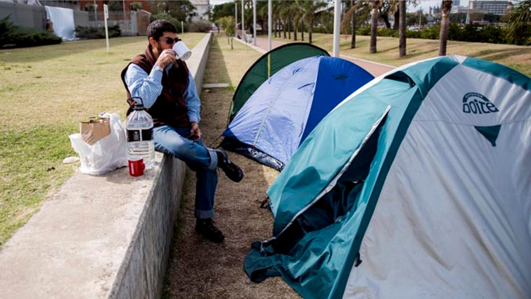 FILE - In this May 6, 2015 file photo, Omar Abdelhadi Faraj drinks tea in front of his tent outside the U.S. embassy as a form of protest in Montevideo, Uruguay. Faraj's attorney Mauricio Pigola said Sunday, Jan. 24, 2016 that his client was released after a judge found insufficient evidence against him in a domestic violence case. Faraj is a Syrian who arrived to Uruguay in December 2014 with five other ex-prisoners once held with terror suspects at the U.S. military base in Guantanamo, Cuba. (AP Photo/Matilde Campodonico, File)