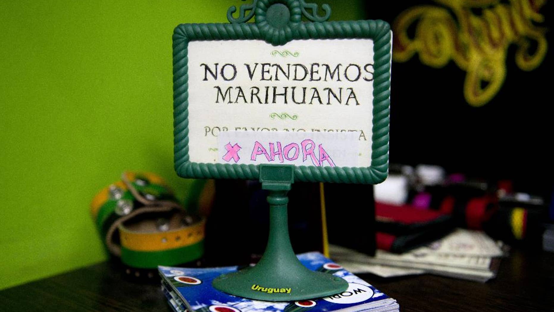 FILE - This May 6, 2014 file photo shows a sign that reads in Spanish; "We don't sell pot, yet," on display at a head shop in downtown Montevideo, Uruguay. Delays in implementing the plan to create the world’s first national, government-regulated marketplace for legal pot , are putting it at risk as polls point to opposition gains in October general elections and disapproval of the project by most Uruguayans. (AP Photo/Matilde Campodonico, File)