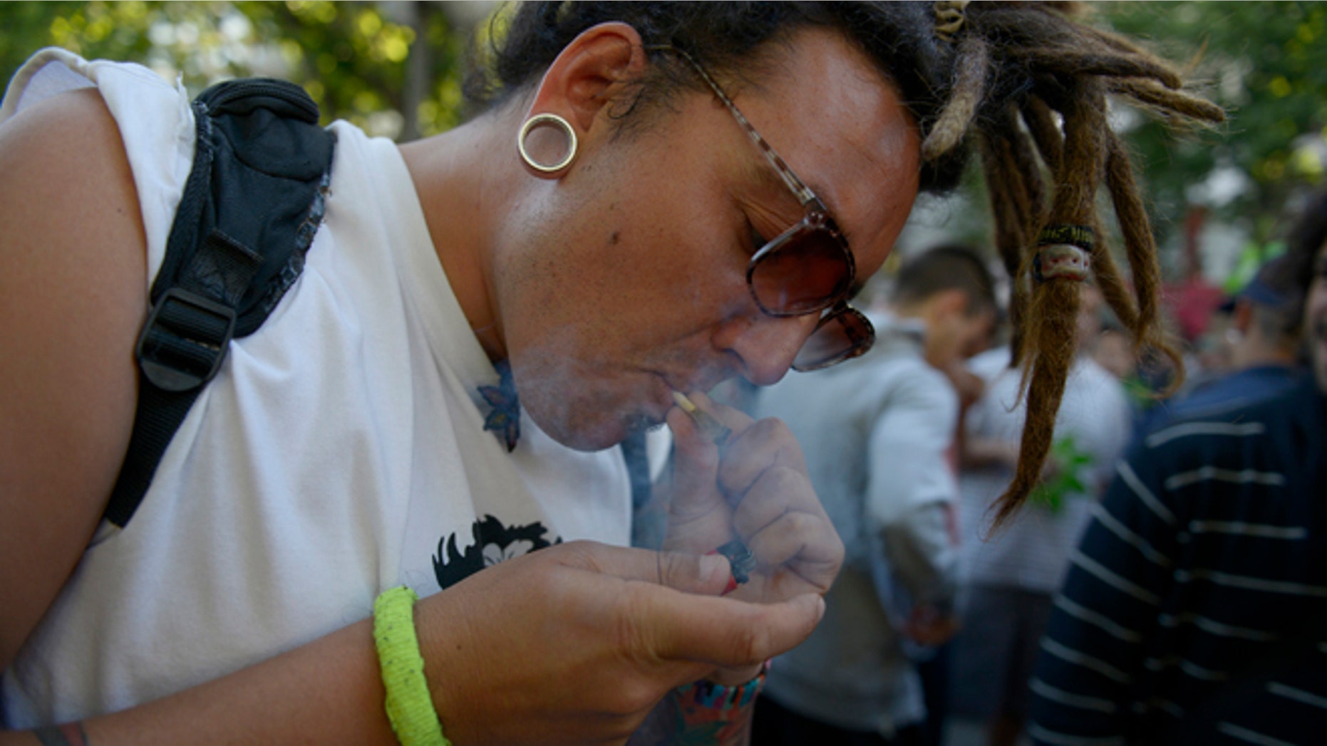 A man smokes a marijuana cigarette during a demonstration in support of the legalization of marijuana outside the Congress in Montevideo, Uruguay, Tuesday, Dec. 10, 2013. Uruguay's Senate was finishing its final debate Tuesday before voting on a plan to create the world's first national marijuana market, with the state regulating the entire process of growing, selling and using a drug that is illegal almost everywhere else. (AP Photo/Matilde Campodonico)