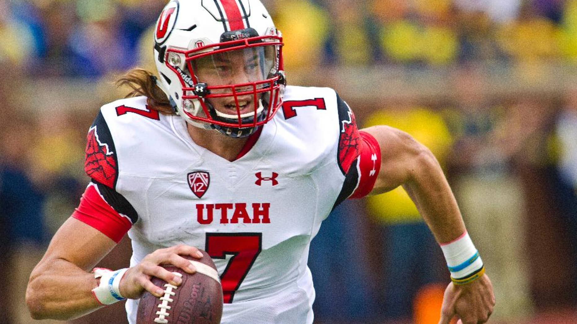 Utah quarterback Travis Wilson (7) scrambles with the ball rushing towards the sideline in the second quarter of an NCAA college football game in Ann Arbor, Mich., Saturday, Sept. 20, 2014. (AP Photo/Tony Ding)