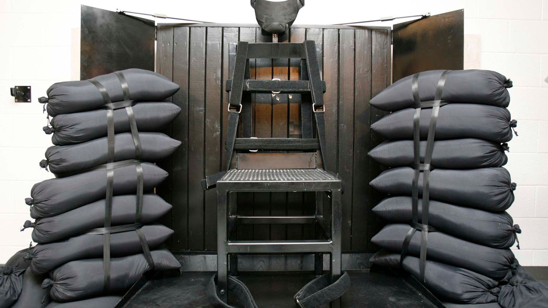 The execution chamber at the Utah State Prison after Ronnie Lee Gardner was executed by firing squad Friday, June 18, 2010. The bullet holes are visible in the wood panel behind the chair. Gardner was convicted of aggravated murder, a capital felony, in 1985. (AP Photo/Trent Nelson - Pool)