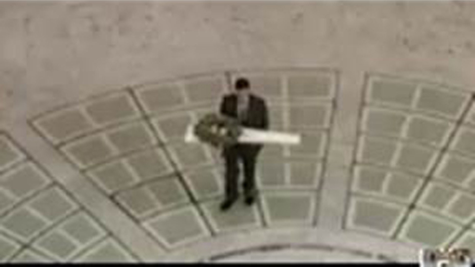 Oct. 15, 2015: This image shows an unidentified man carrying a package containing an unloaded rifle into Utah's state capitol building in Salt Lake City. (Utah Department of Public Safety)