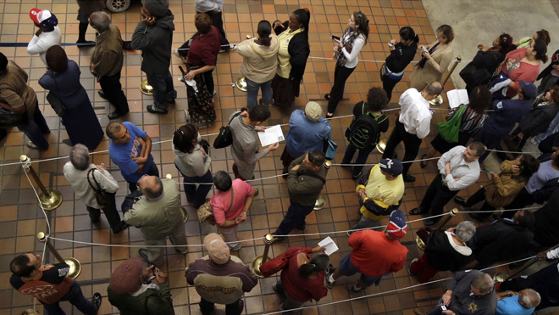 FILE - This Oct. 29, 2012 file photo shows people standing in line to vote during early voting for the presidential election, in Miami. One week before a close election, superstorm Sandy has confounded the presidential race, halting early voting in many areas, forcing both candidates to suspend campaigning and leading many to ponder whether the election might be postponed. It could take days to restore electricity to all of the more than 8 million homes and businesses that lost power when the storm pummeled the East Coast. That means itâs possible that power could still be out in some states on Election Day _ a major problem for areas that rely on electronic voting machines. (AP Photo/Lynne Sladky, File)
