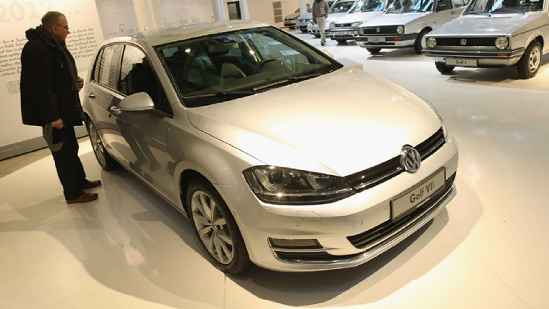 BERLIN, GERMANY - JANUARY 14: A visitor looks at a VW Golf VII as the six previous generations of Volkswagen cars stand lined up behind at a Volkswagen Group showroom on January 14, 2013 in Berlin, Germany. Volkswagen Group, which includes the VW, Audi, Porsche, Skoda, SEAT, Bentley and Bugatti brands, delivered a record 9.07 million cars to customers in 2012. Rising sales in the Americas and Asia helped to offset a drop in sales in western Europe. (Photo by Sean Gallup/Getty Images)