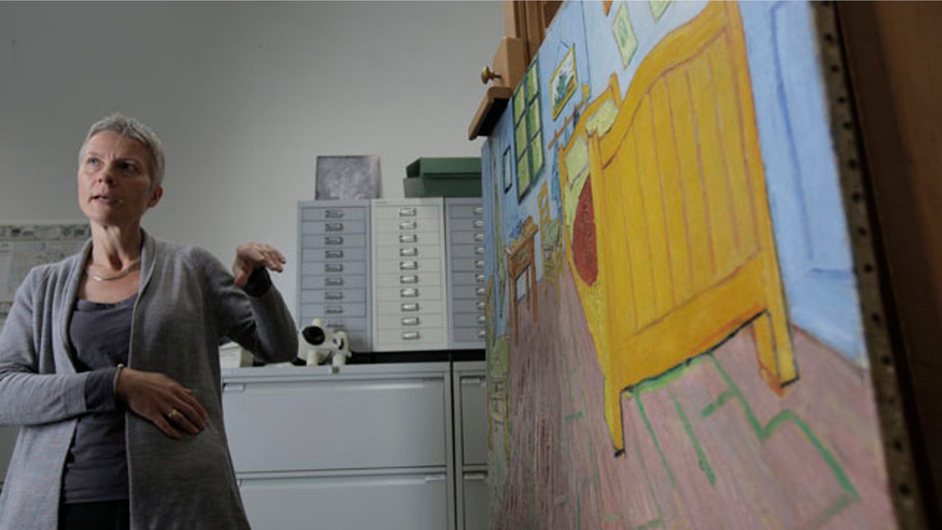 August 27: Restorer Ella Hendriks comments on the restoration of Vincent Van Gogh's 'The Bedroom' painting, right on easel, at the Van Gogh museum in Amsterdam, Netherlands. (AP)