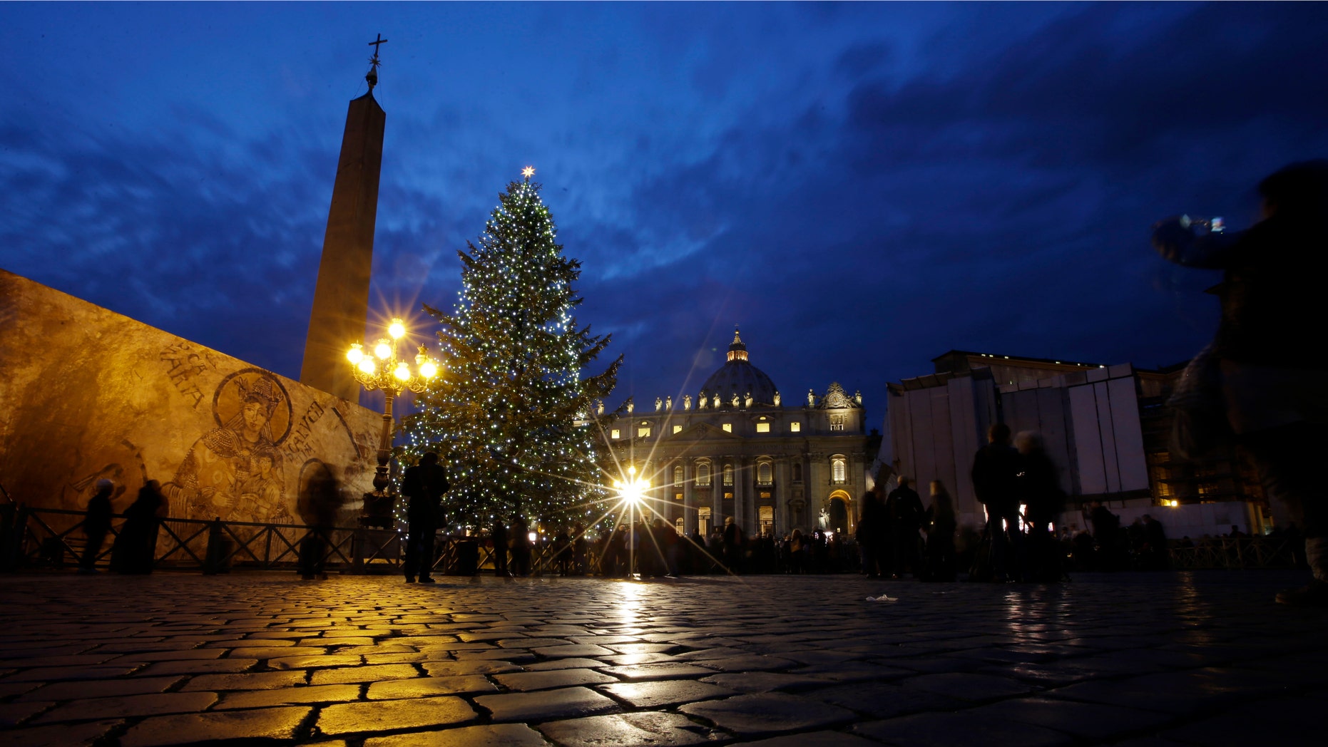 The 24 meters (78.74 feet) Christmas tree is lit in St. Peter's square at the Vatican, Friday, Dec. 14, 2012. The Christmas season kicks off Friday at the Vatican with the traditional lighting of the tree in St. Peter's Square and a reminder from the Pope about what happened when the "lights" of God were turned off in past atheistic regimes. (AP Photo/Gregorio Borgia)