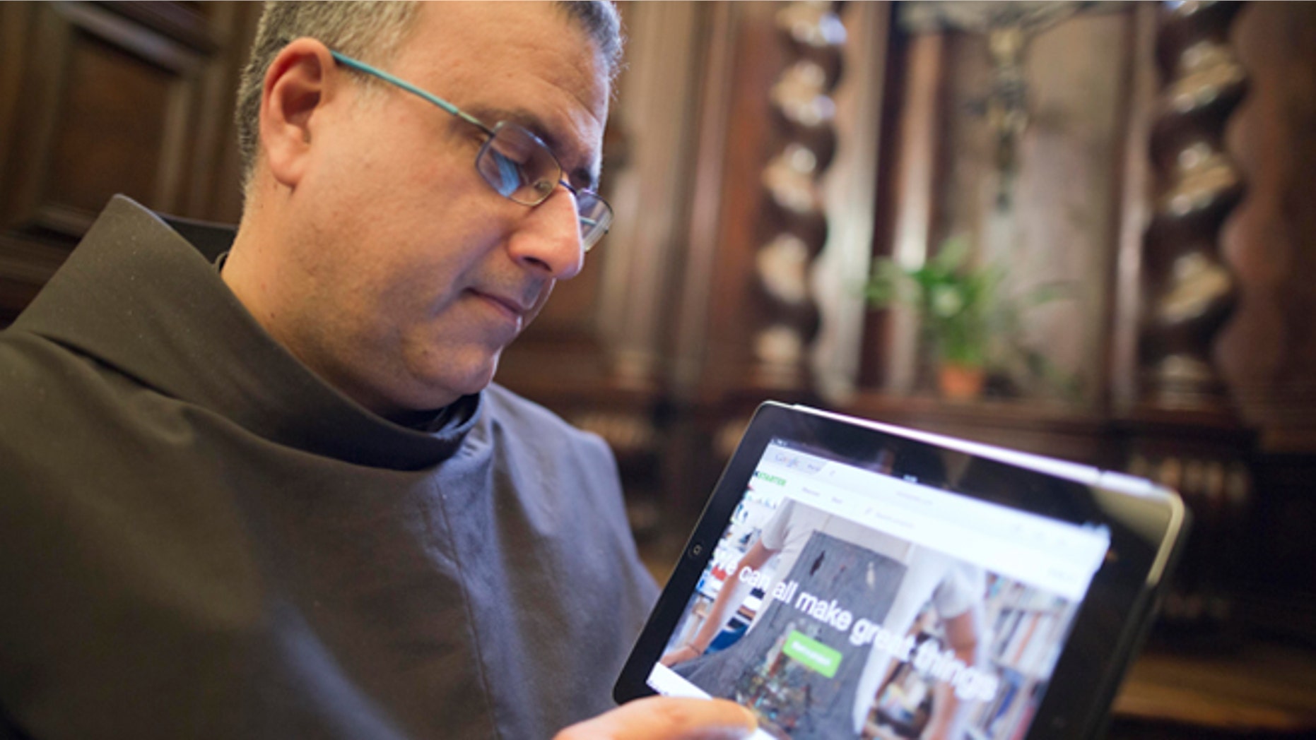 The head of the Franciscan convent of St. Francesco a Ripa, Friar Stefano Tamburo, uses a tablet device to check the Kickstart page promoting the conservation works required in the cell that St. Francis of Assisi is believed to have used when visiting the convent in Rome, Friday, Feb. 28, 2014. The friars who run the St. Francis a Ripa church in Rome's Trastevere neighborhood are launching a Kickstarter online fundraising campaign Tuesday, March 11, 2014, to try to raise the $125,000 to restore the tiny cell where St. Francis stayed when he came to Rome to see the pope, The Associated Press has learned. Rather than ask for funding from the Italian government, which owns the church and is responsible for its upkeep, the friars decided on this more democratic crowdfunding initiative thinking it more in keeping with the Franciscan tradition of seeking alms for just what they need, spreading the faith as they beg, and making sure the poor are the priority. (AP Photo/Domenico Stinellis)