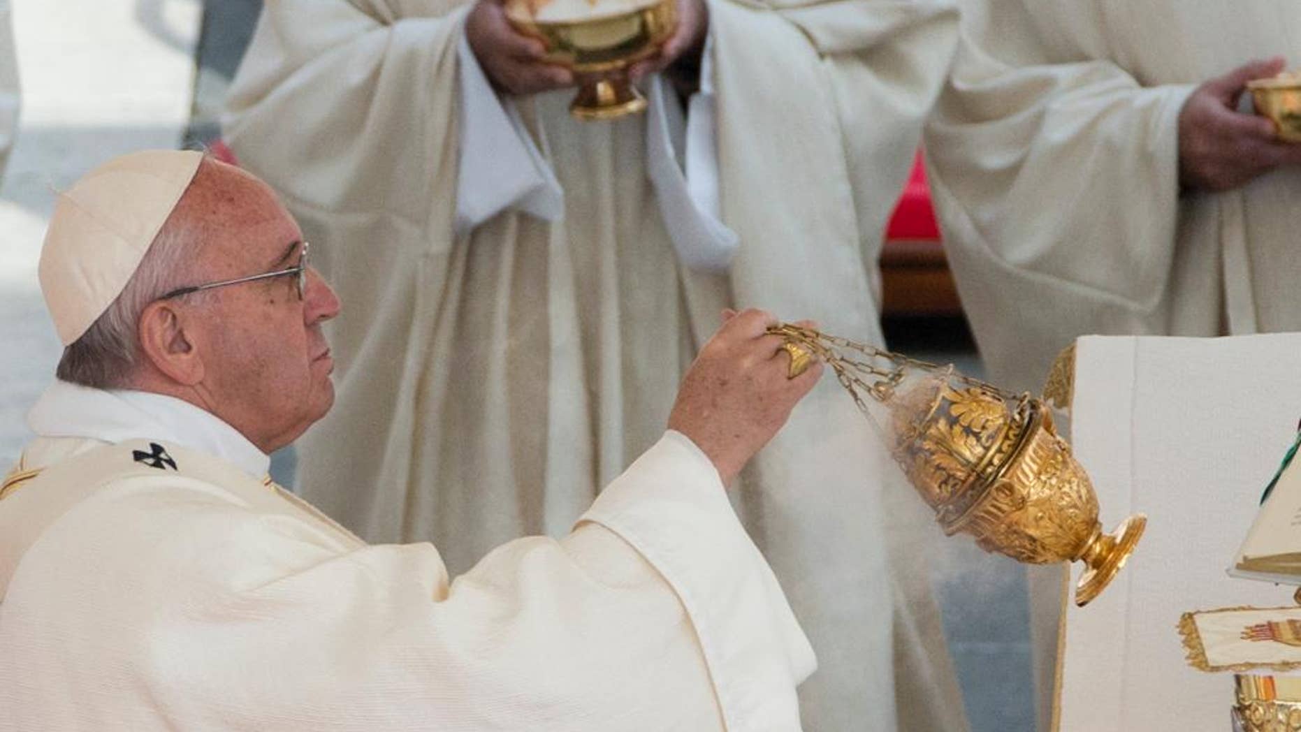Pope Francis spreads incense during a canonization ceremony in St. Peter's Square at the Vatican Sunday, Oct. 18, 2015. Pope Francis canonized the Catholic Church's first married couple in modern times on Sunday, declaring the parents of the beloved St. Therese of Lisieux saints in their own right. (AP Photo/Alessandra Tarantino)