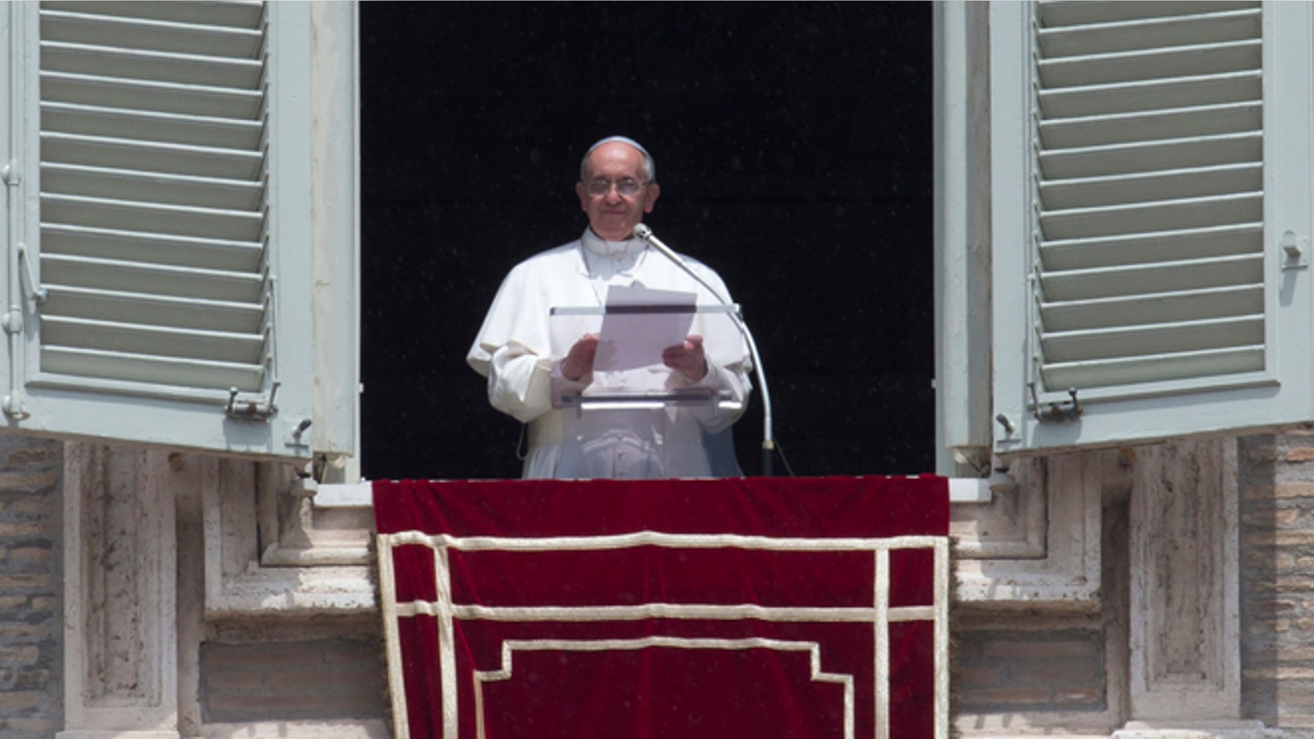 Pope Francis reads a message during the Angelus noon prayer he celebrated from the window of his studio overlooking St. Peter's square at the Vatican, Sunday, June 9, 2013.(AP Photo/Alessandra Tarantino)