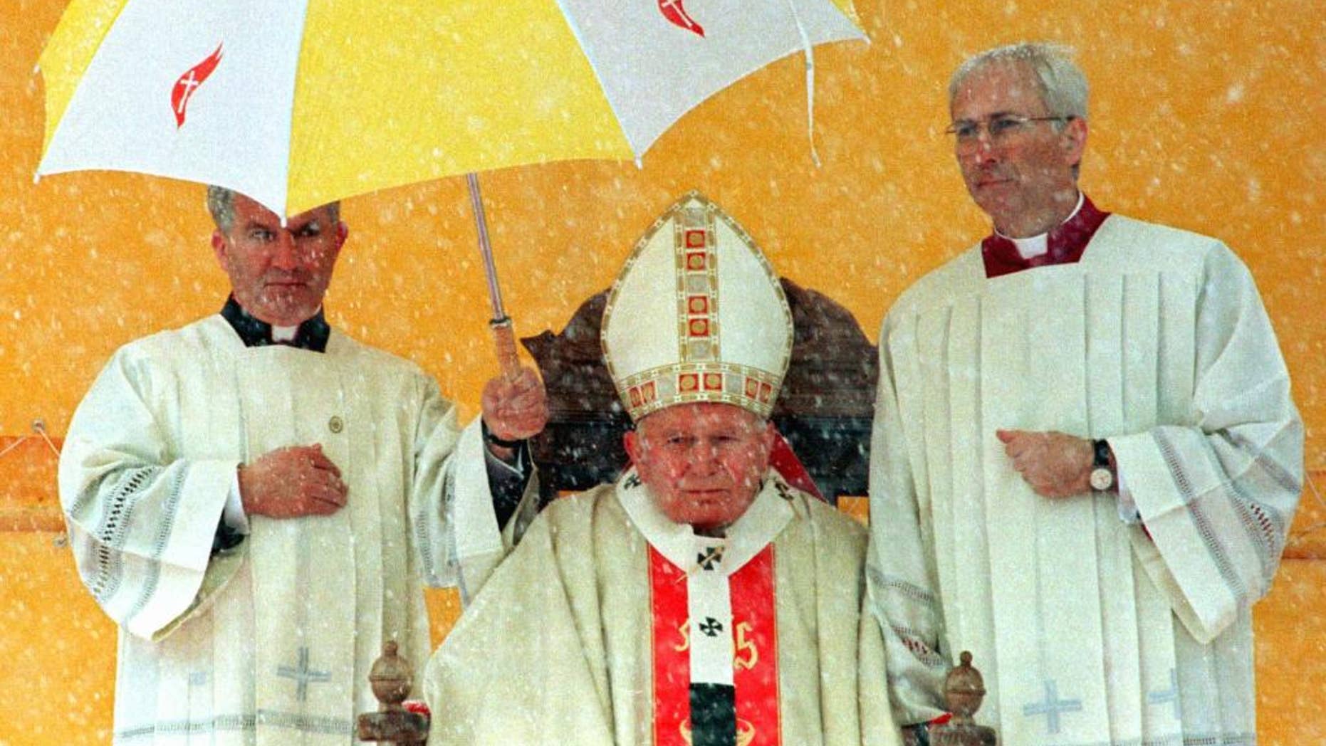 FILE - In this Sunday April 13, 1997 file photo clergymen hold an umbrella over Pope John Paul II during a snow storm as the Holy Father celebrates a Mass for tens of thousands of Bosnian worshippers at Sarajevo Kosevo Stadium. Anxiety has so gripped American conservatives over Pope Francis' upcoming encyclical on the environment that you might think a pope had never before blamed fossil fuels for global warming. Or accused energy companies of hoarding the Earth's resources at the expense of the poor. Or urged the rich to consume less and share more. (AP Photo/Jacqueline Arzt, file)