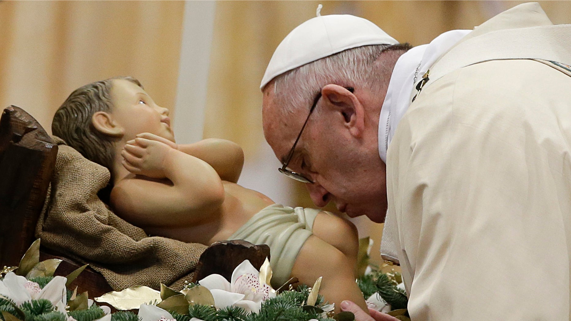 Pope Francis kisses during statue of baby Jesus a Mass in St. Peter's Basilica, at the Vatican, to mark Epiphany, Wednesday, Jan. 6, 2016. The Epiphany day is a joyous day for Catholics in which they recall the journey of the Three Kings, or Magi, to pay homage to Baby Jesus (AP Photo/Gregorio Borgia)