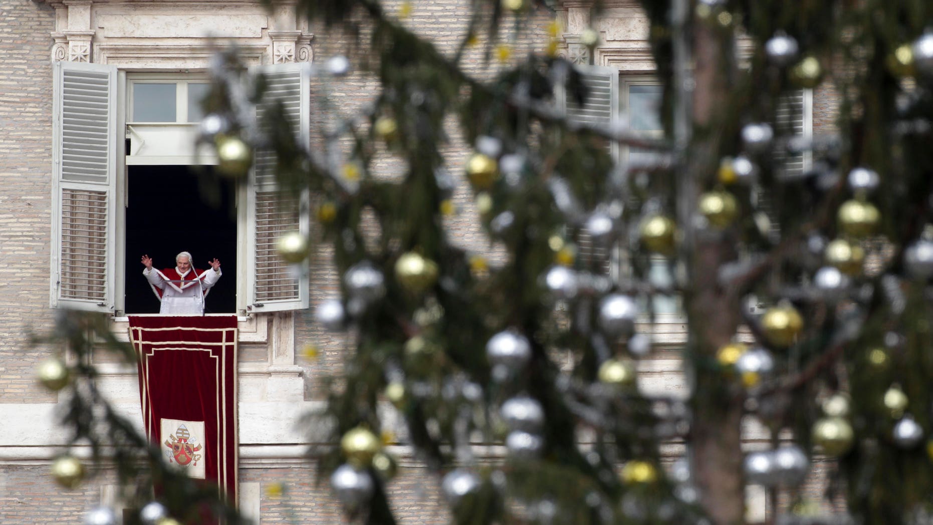 Jan. 6, 2011: Pope Benedict XVI, framed by a Christmas tree, delivers his blessing from his studio window overlooking St. Peter's Square following an Epiphany Mass, at the Vatican. Benedict XVI is stunned by the wave of violence and intolerance toward Christians around the world, Italy's top churchman said at Epiphany services.