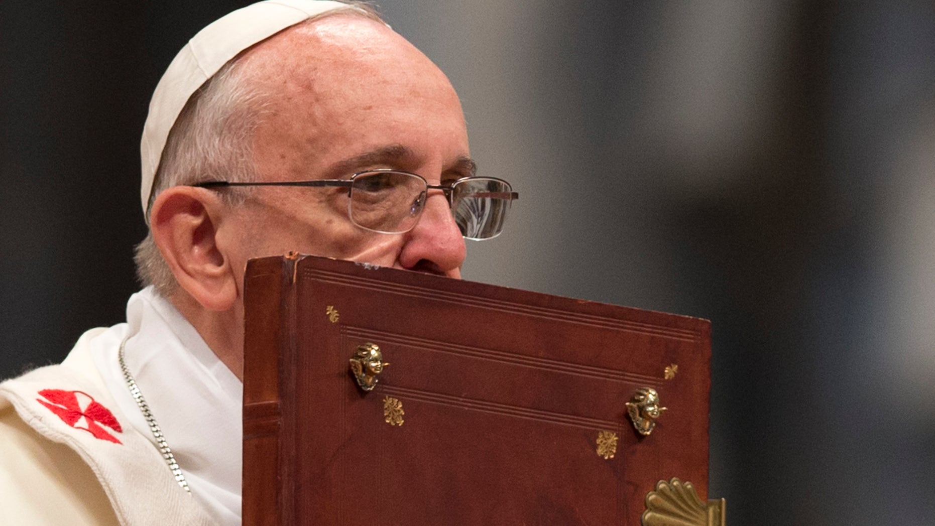 Pope Francis kisses the Holy Book as he celebrates a mass in St. Peter's Basilica on Jan. 1, 2014.
