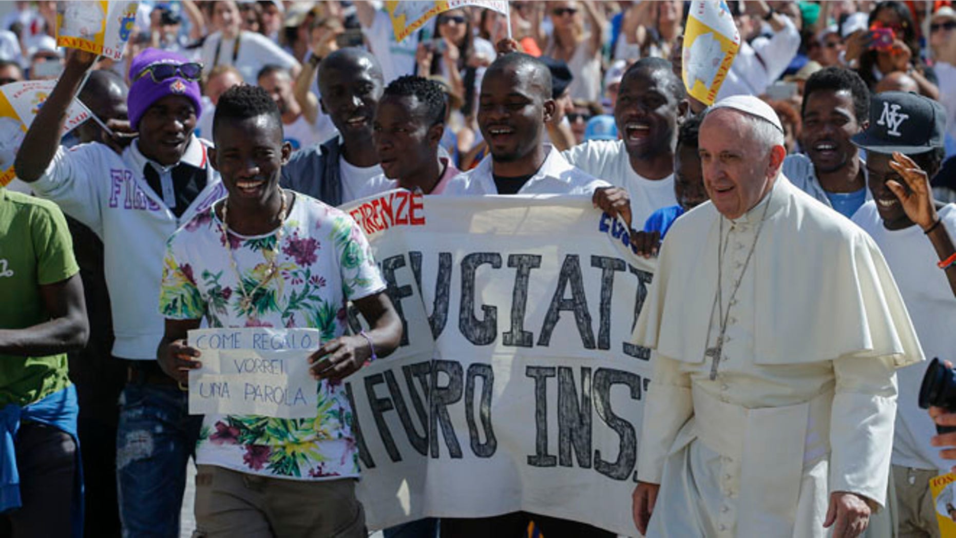 FILE- In this file photo dated Wednesday, June 22, 2016, Pope Francis walks with a group of refugees he invited to join him on the steps of St. Peter's Basilica during his weekly general audience in St. Peter's Square at the Vatican. Pope Francis begins a five-day visit to Poland on upcoming Wednesday July 27, 2016, and hopes to inspire aid to homeless strangers and acts of mercy for refugees during his visit, although Poland has closed its borders to refugees. (AP Photo/Fabio Frustaci, FILE)