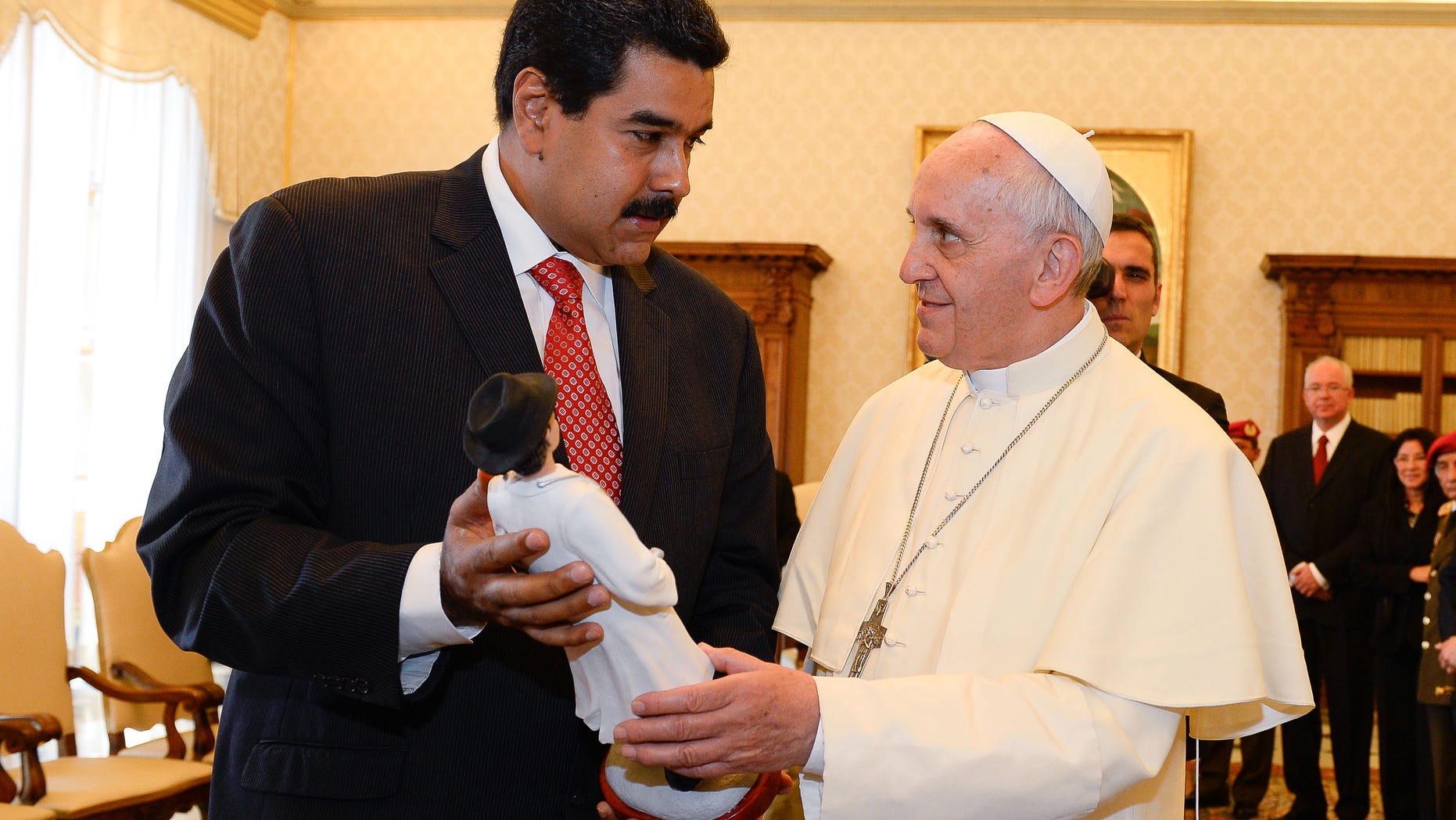 Venezuelan President Nicolas Maduro, left, gives Pope Francis a statuette of Venezuela's Jose' Gregorio Hernandez, a popular figure amongst Venezuelans whom Maduro expressed hope for his canonization on the occasion of their private audience at the Vatican, Monday, June 17, 2013. (AP Photo/Andreas Solaro, pool)