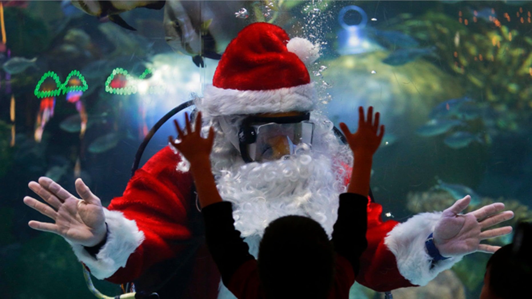 Jerry Cowley, aquatic safety manager at the Silverton Hotel-Casino interacts with children as an underwater Santa Claus, at the casino's aquarium in Las Vegas.