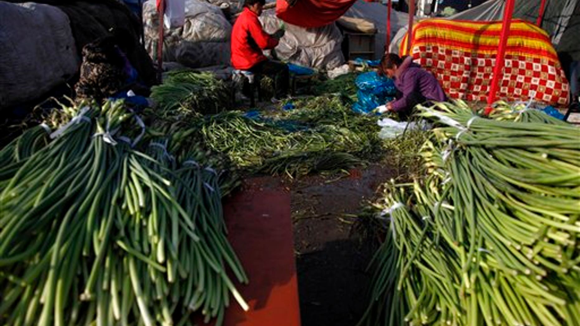 March 16: Vendors clean vegetables at a wholesale market in Beijing, China. In the U.S. the costs of corn, wheat, cotton and other commodities have jumped due to strong global demand.