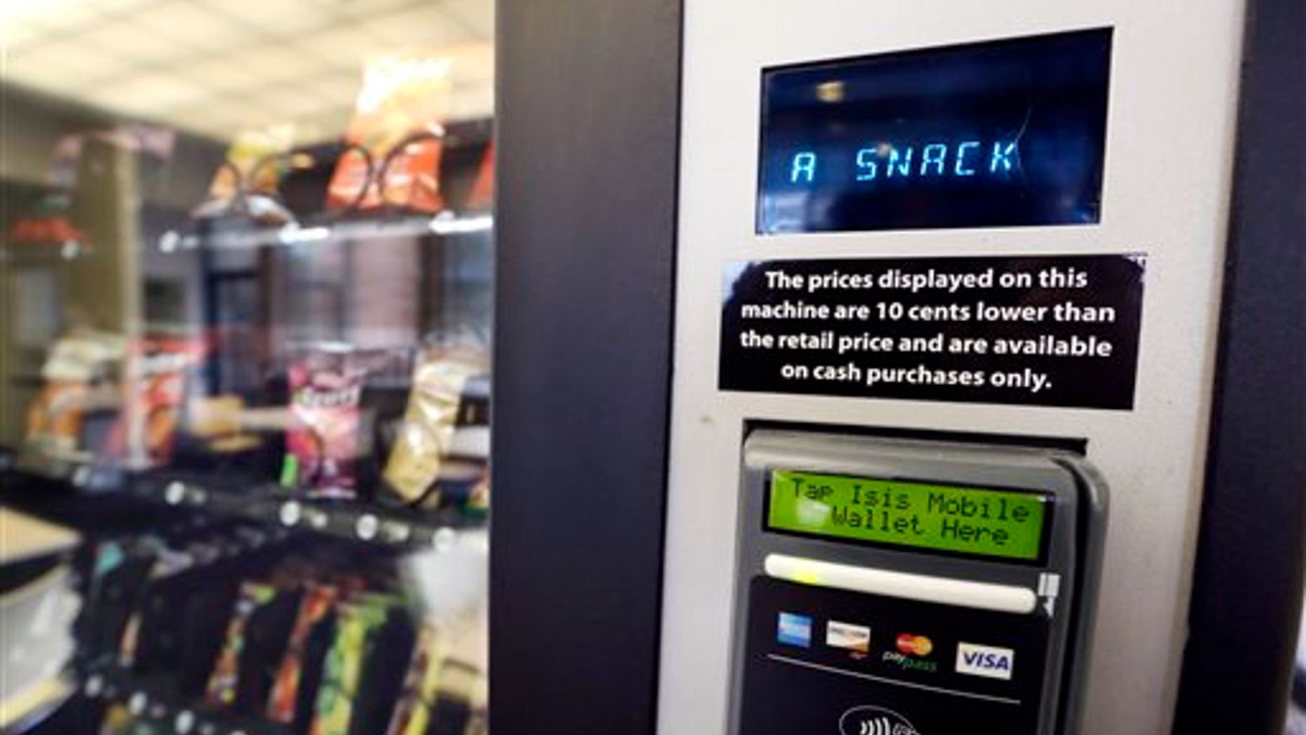 In this Dec. 23, 2013 photo, a vending machine advertises snacks on a small screen on the machine in Seattle. Office workers in search of snacks will be counting calories along with their change under new labeling regulations for vending machines included in President Barack Obama's health care overhaul law. The Food and Drug Administration, which is expected to release final rules early next year, says requiring calorie information to be displayed on roughly 5 million vending machines nationwide will help consumers make healthier choices. (AP Photo/Elaine Thompson)