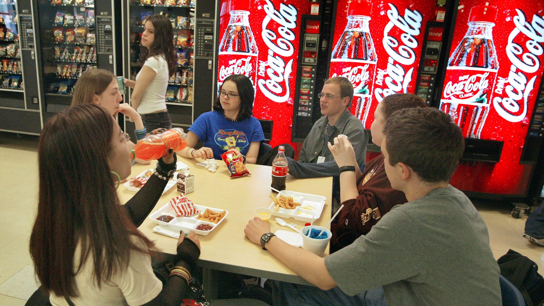 CHICAGO - APRIL 20: Students eat lunch before a bank of vending machines at Jones College Prep High School April 20, 2004 in Chicago, Illinois. The Chicago Public School system will introduce next fall a new vending policy restricting junk food and a new beverage contract banning carbonated drinks. (Photo by Tim Boyle/Getty Images)
