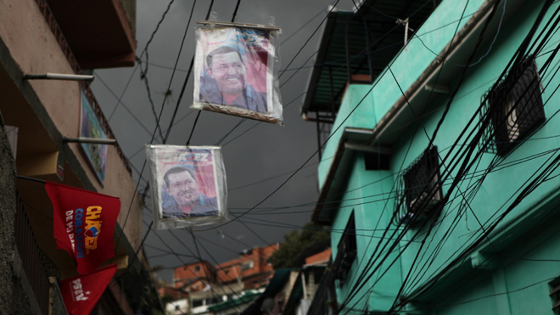 Posters of Venezuela's President Hugo Chavez hang over a street in the Petare neighborhood of Caracas, Venezuela, Friday, Oct. 5, 2012. The last time he ran for re-election, Chavez won comfortably in Petare, one of Latin America's biggest slums with nearly half a million people. This time around, as Venezuelans vote Sunday, he may not. The neighborhood is divided, owing in some degree to mismanagement by pro-Chavez mayors and governors who were voted out of office in 2008 and 2010, respectively. (AP Photo/Rodrigo Abd)