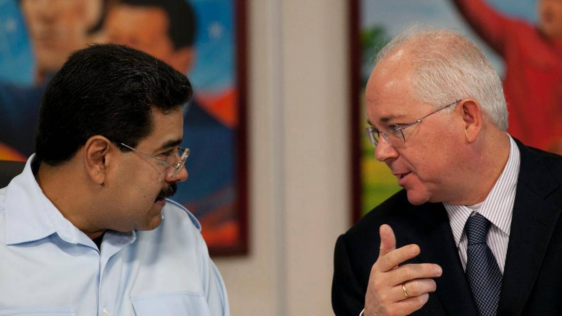 FILE - In this Nov. 15, 2013, file photo, Venezuela's President Nicolas Maduro, left, speaks with his Oil Minister Rafael Ramirez before the start of a press conference at Miraflores presidential palace in Caracas, Venezuela. President Maduro has replaced on Tuesday Sept. 2, 2014, Venezuela's longtime oil minister and economic czar as part of a cabinet shakeup sidelining the most-prominent voice within his administration for much-needed reforms to address the country's economic crisis. (AP Photo/Ariana Cubillos, File)