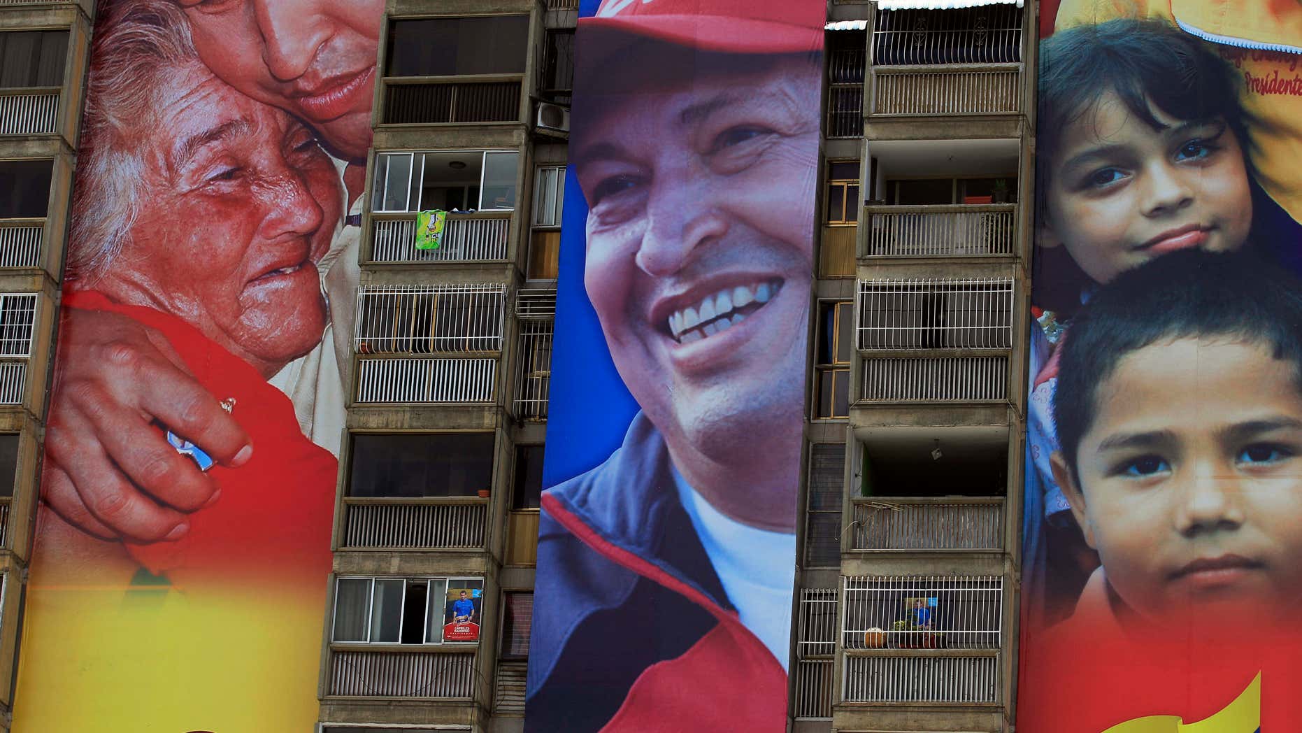 Campaign re-election posters of Venezuela's President Hugo Chavez tower over the posters of opposition presidential candidate Henrique Capriles, on an apartment building in Caracas, Venezuela, Tuesday, Aug. 21, 2012. A little more than a month ahead of Venezuela's Oct. 7, election, Chavez enjoys clear advantages over his challenger in campaign funding and media access. While neither campaign has revealed how much it's spending, Capriles says he is in a David versus Goliath contest, facing a well-financed incumbent backed by an even richer government. (AP Photo/Fernando Llano)