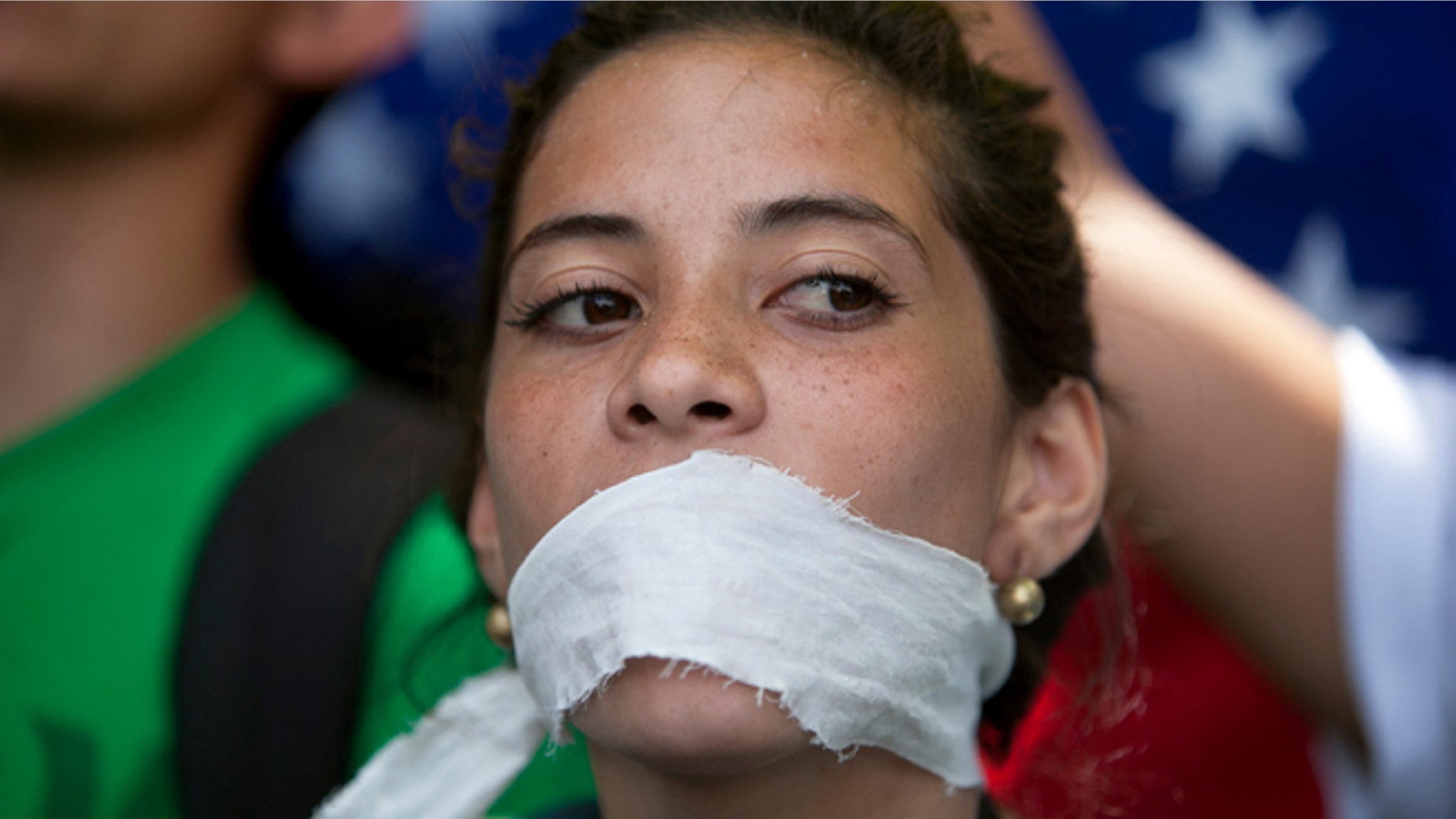 A demonstrator covers her mouth with a rag to prostest government censorship, during a march to Venezuelan Telecommunications Regulator Office or CONATEL in Caracas, Venezuela, Monday, Feb17, 2014. Students, whoâve spent the past week on the streets alternating between peaceful protests by day and battles with police at night, marched on Monday to Venezuelaâs telecom regulator to demand it lift all restrictions on the mediaâs coverage of the unfolding political crisis. (AP Photo/Alejandro Cegarra)