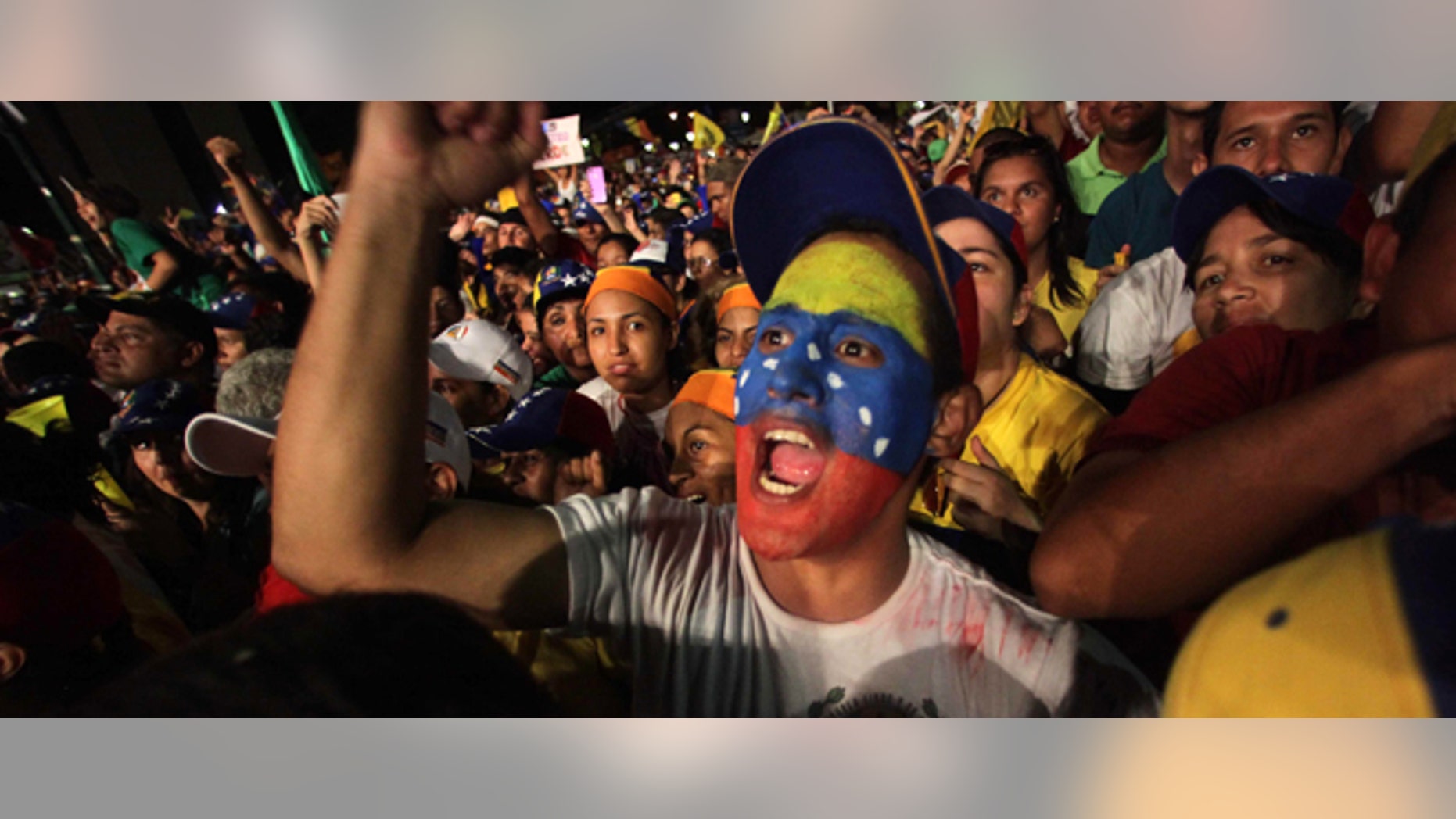 Supporters of opposition presidential candidate Henrique Capriles, one with his face painted with the colors of the Venezuelan flag, cheer during his closing campaign rally in Barquisimeto, Venezuela, Thursday, Oct. 4, 2012. Capriles will run against President Hugo Chavez in the presidential elections Oct. 7. (AP Photo/Fernando Llano)