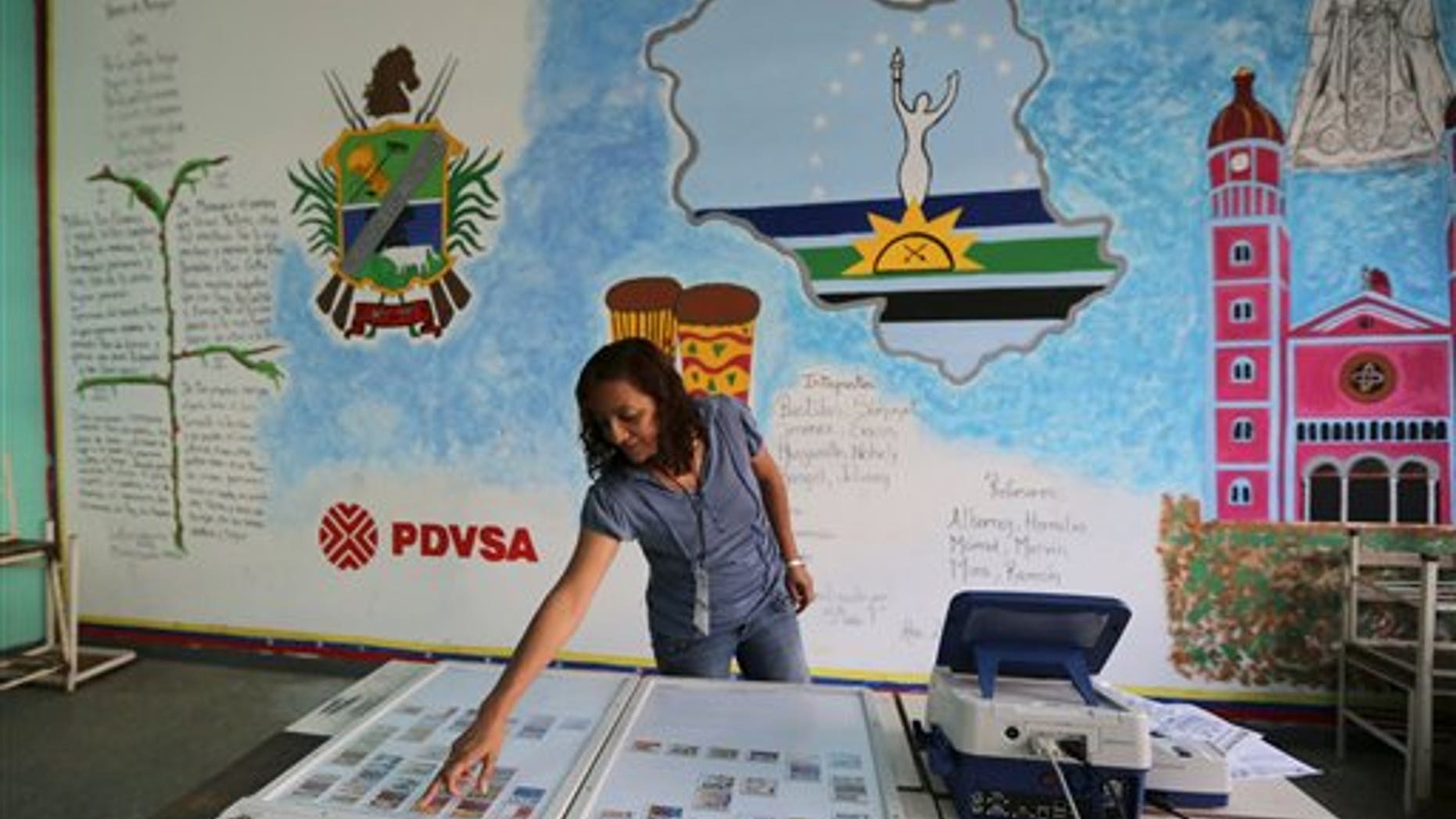 A member of the Venezuelan National Electoral Council tests a voting machine at a polling station in Caracas, Venezuela, Friday, Dec. 6, 2013. Venezuelans will vote in nationwide municipal elections Sunday. (AP Photo/Fernando Llano)