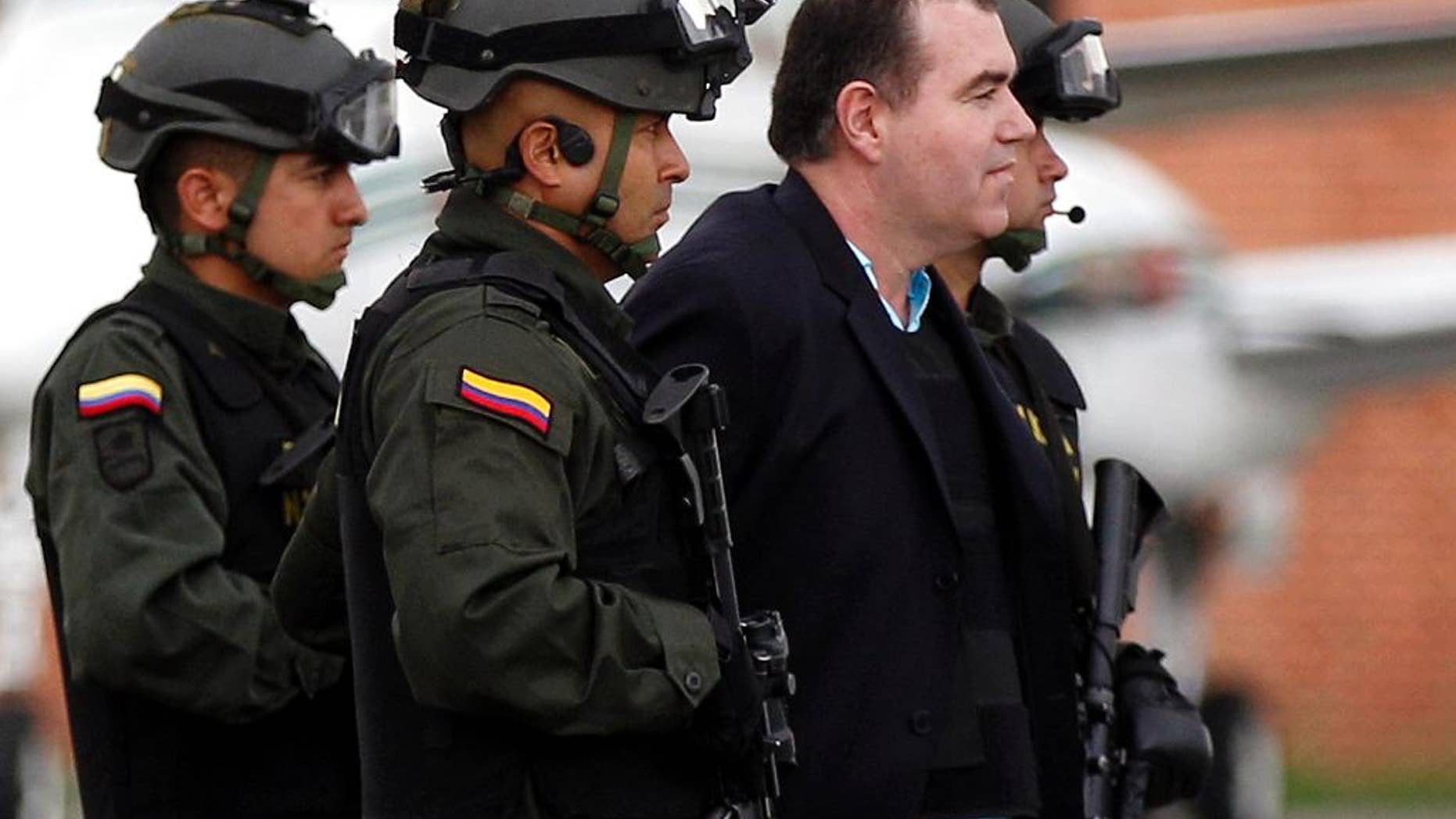 FILE - In this May 9, 2011, file photo, Colombian police officers escort alleged drug trafficker Walid “The Turk” Makled to a waiting plane at the military airport in Bogota, Colombia. The Venezuelan citizen of Syrian descent was arrested late last year on a U.S. warrant in Colombia. Venezuelan authorities have arrested judge Ali Fabricio Paredes on Wednesday Feb. 11, 2015, less than 24 hours after he issued a sentence in the high-profile drug trafficking case against drug kingpin Makled, that prosecutors say is too lenient. The state prosecutor’s office says Paredes will face charges related to favoritism.(AP Photo/Fernando Vergara,File)