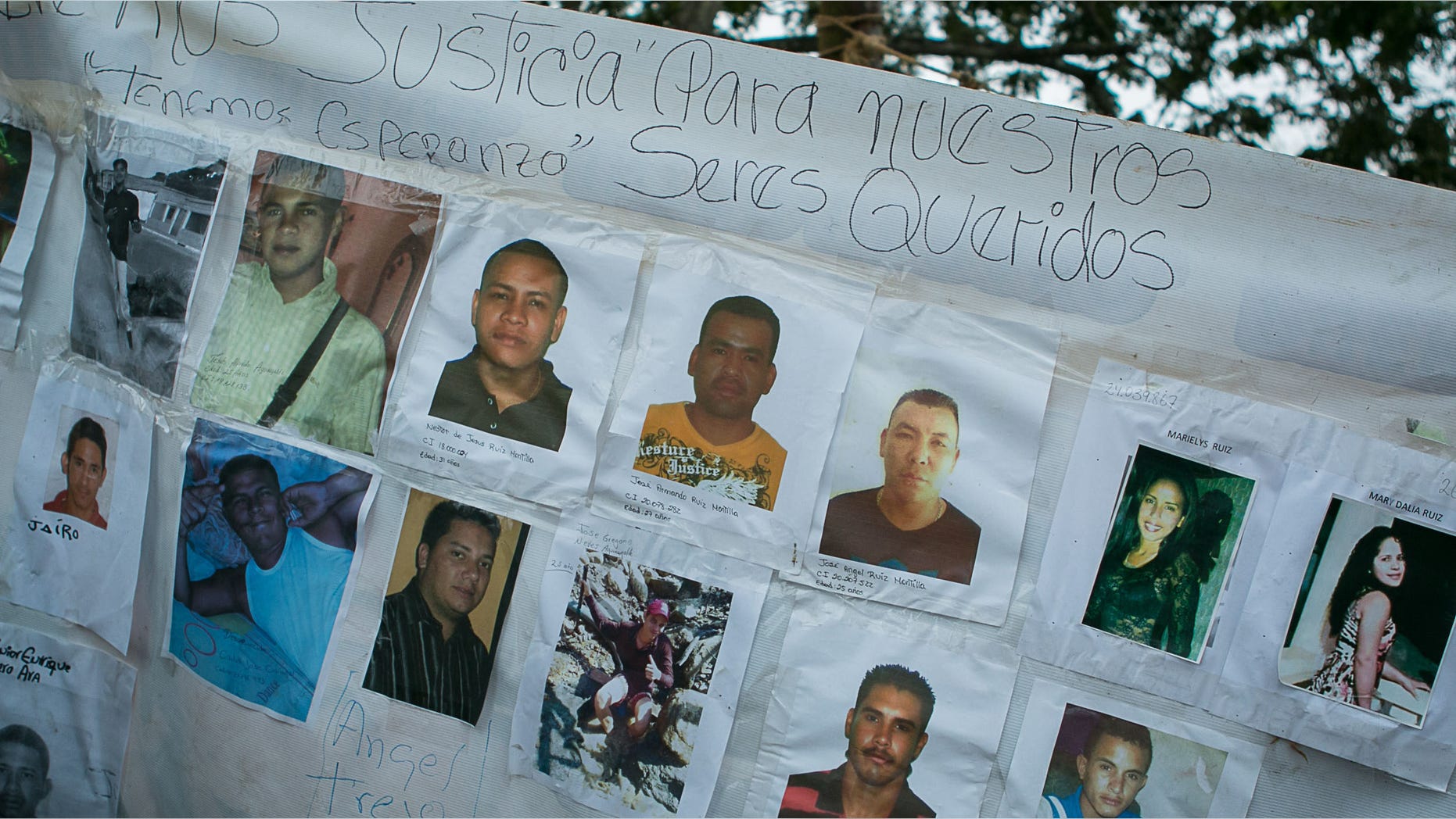 A banner with photos of several missing miners hangs on a tree near Tumeremo, Venezuela, Tuesday, March 8, 2016.