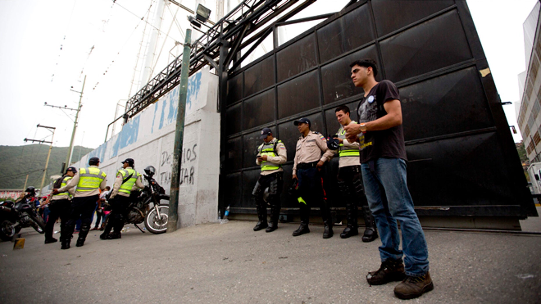 A group of Bolivarian Police officers stand at the gate of distribution center belonging to Venezuelas largest food company, Empresas Polar, in La Yaguara in Caracas, Venezuela, Thursday, July 30, 2015. According to Empresas Polar director Manuel Felipe Larrazabal the government occupied of one of its Caracas food distribution centers. President Nicolas Maduro has accused Polar of sabotaging the economy by hoarding goods and intentionally creating shortages, a charge the company has denied. (AP Photo/Ariana Cubillos)