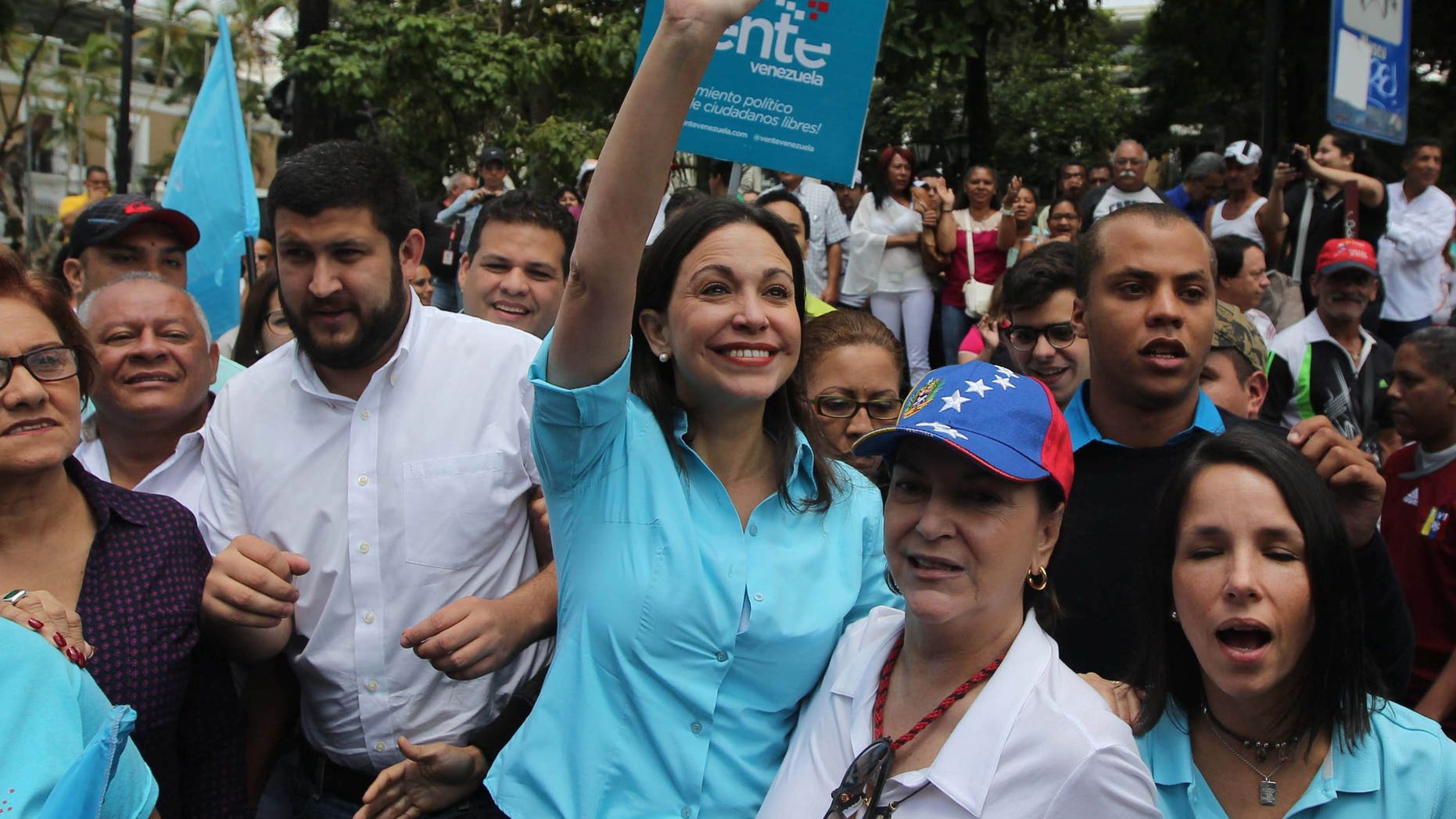 Monday, Aug. 3, 2015: Opposition leader Maria Corina Machado waves as she and her supporters arrive to the National Electoral Council (CNE) with the intention of registering her candidacy for congressional elections in Los Teques, Venezuela.