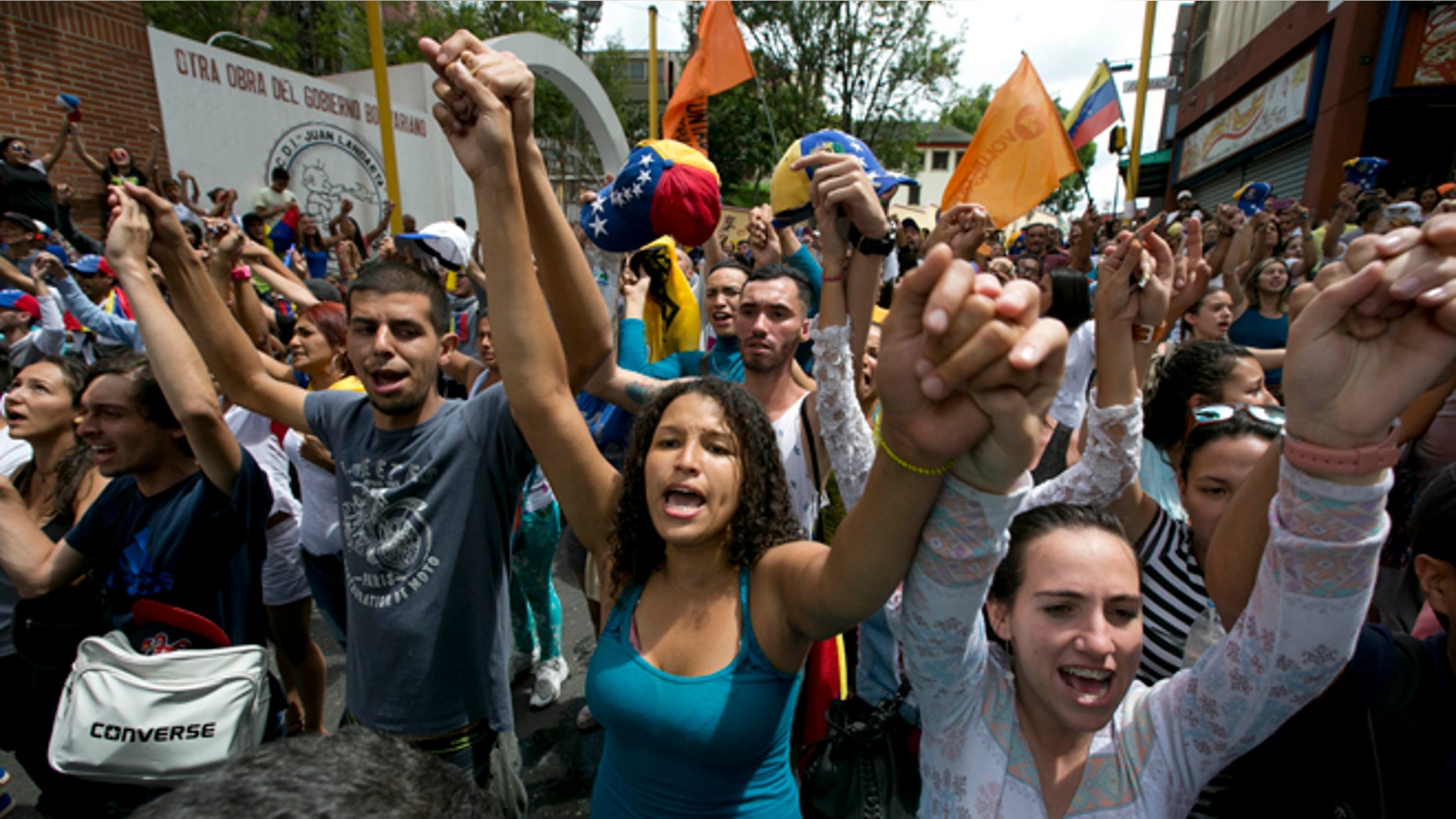 FILE - In this Sept. 7, 2016, file photo, demonstrators sing Venezuela's national anthem during a protest against the government of Venezuela's President Nicolas Maduro in Los Teques on the outskirts of Caracas, Venezuela. As the country's economy has only gone further into its tailspin the Venezuelan professional class that makes up the bedrock of the oppositions support is eager to see President Nicolas Maduro go. (AP Photo/Ariana Cubillos, File)