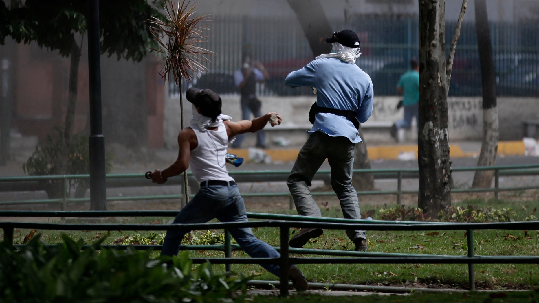 Relatives of inmates protesting against measures taken by authorities to control a riot at the La Planta prison clash with National Guard soldiers outside the jail in Caracas, Venezuela, Thursday, May 17, 2012. (AP Photo/Ariana Cubillos)