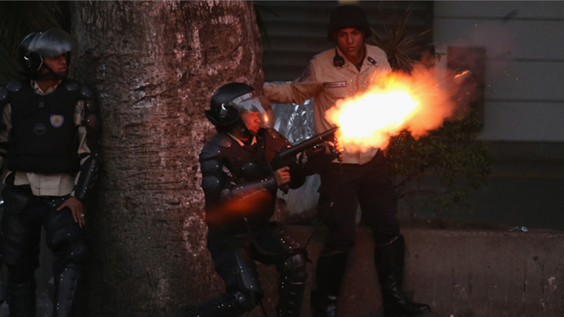 CARACAS, VENEZUELA - MARCH 06: Venezuelan national police fire tear gas at anti-government protesters on March 6, 2014 in Caracas, Venezuela. Three weeks of protests against the federal government have shaken the country as business in much of the nation has come to a standstill. (Photo by John Moore/Getty Images)