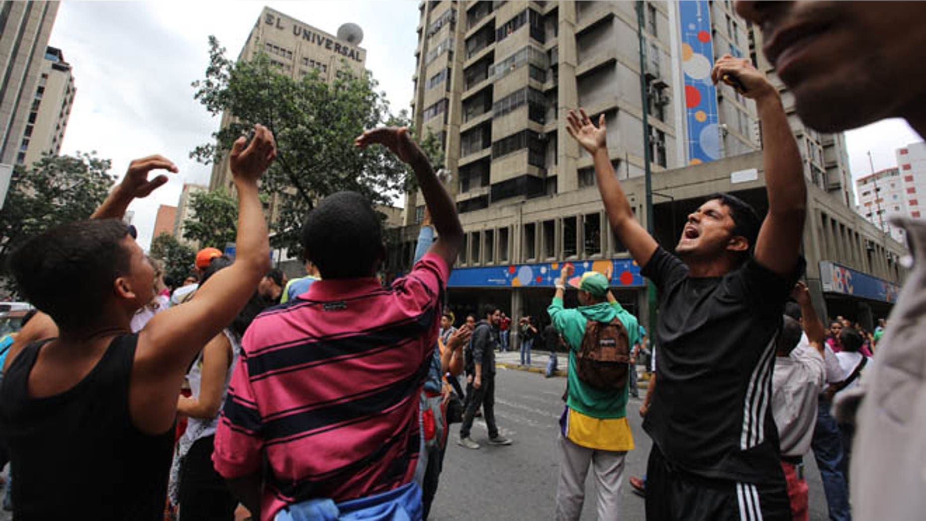 People call others in apartment and office buildings to join their protest demanding food, a few blocks from Miraflores presidential palace in Caracas, Venezuela, Thursday, June 2, 2016. Venezuela is seeing rising frustration with widespread food shortages and triple-digit inflation. (AP Photo/Fernando Llano)