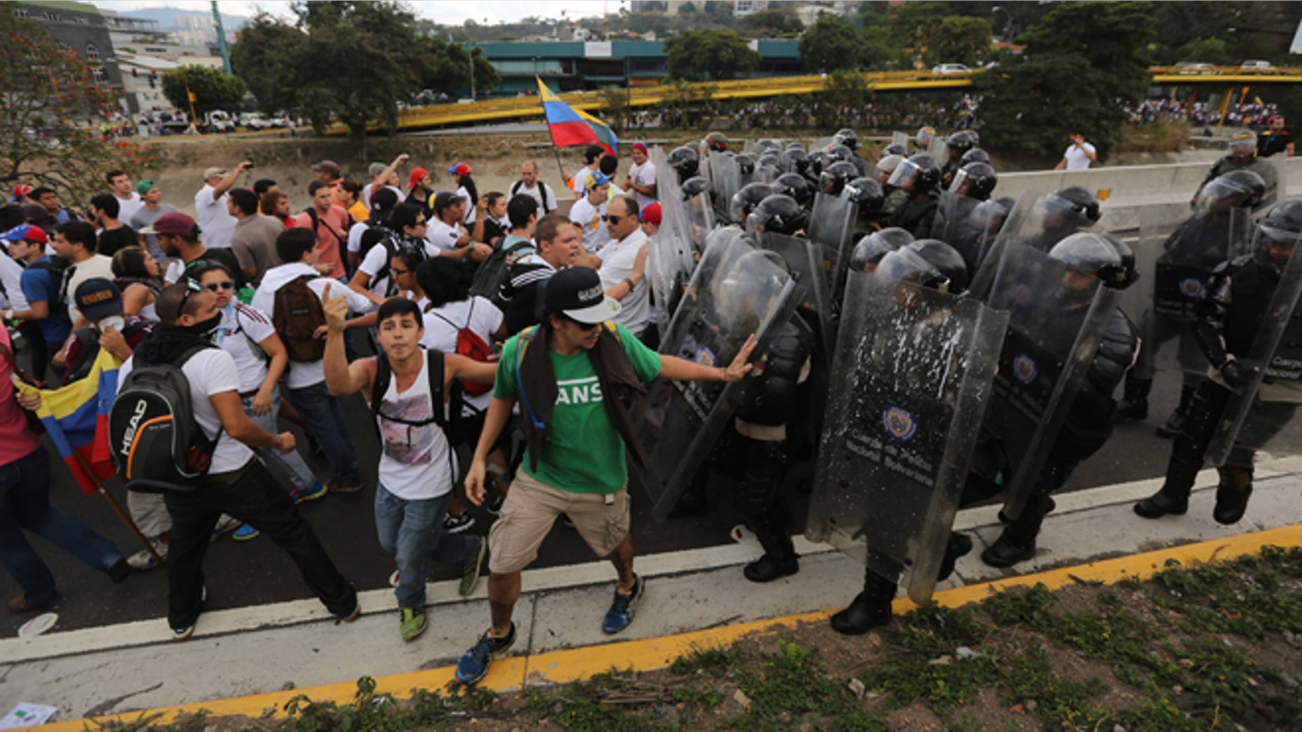 Bolivarian National Police officers push demonstrators to prevent them from blocking the Francisco Fajardo highway in Caracas, Venezuela, Thursday, Feb. 27, 2014. Anti-government protesters rallied to demand an end to the government crackdown on protests and the release of those jailed in recent weeks. (AP Photo/Fernando Llano)