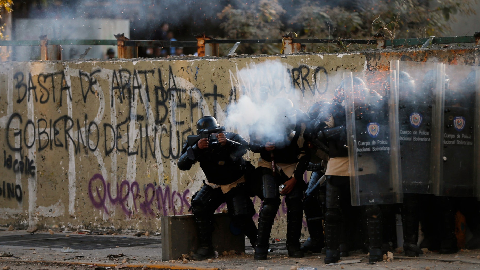 Police officers fire teargas at demonstrators during clashes in Caracas, Venezuela, Wednesday, March 5, 2014.