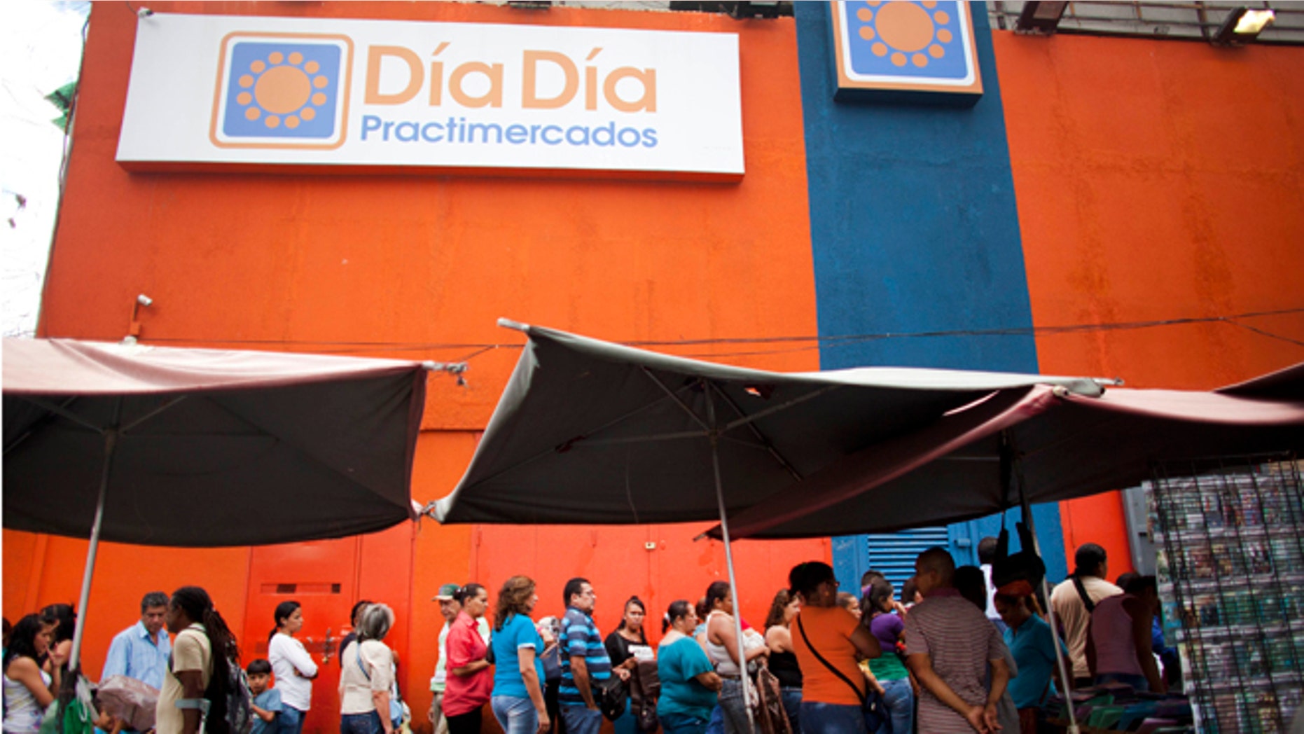 People line up outside the Dia a Dia supermarket after it was taken over by the government in the Propatria neighborhood of Caracas, Venezuela, Tuesday, Feb. 3, 2015. The government is temporarily taking over the Dia a Dia supermarket chain as part of a crackdown on private businesses it blames for worsening shortages and long lines. Popular items with government fixed prices that have been running short are coffee, cooking oil, precooked corn flour, sugar, milk, toilet paper, disposable diapers, detergent and fabric softener, among other items. (AP Photo/Ariana Cubillos)