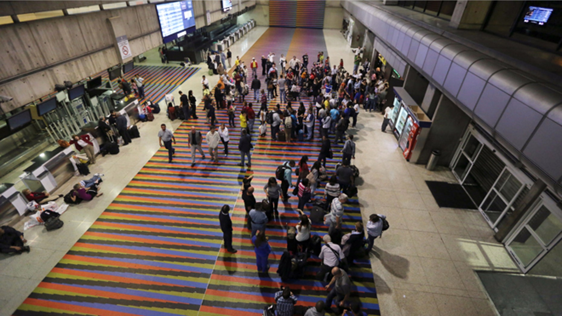 Passengers lineup in front of the Air France desk after their flight to Paris was called at Simon Bolivar Airport in Maiquetia near Caracas, Venezuela, Sunday, Dec. 15, 2013. Venezuelan bomb experts are inspecting a grounded Air France flight after being tipped off by French authorities that a terrorist group may be planning to detonate an explosive device in midair. Venezuelan Interior Minister Miguel Rodriguez Torres told state TV that a team of more than 60 technicians are performing an exhaustive search of the aircraft that will take several hours before the flight can be rescheduled.(AP Photo/Fernando Llano)