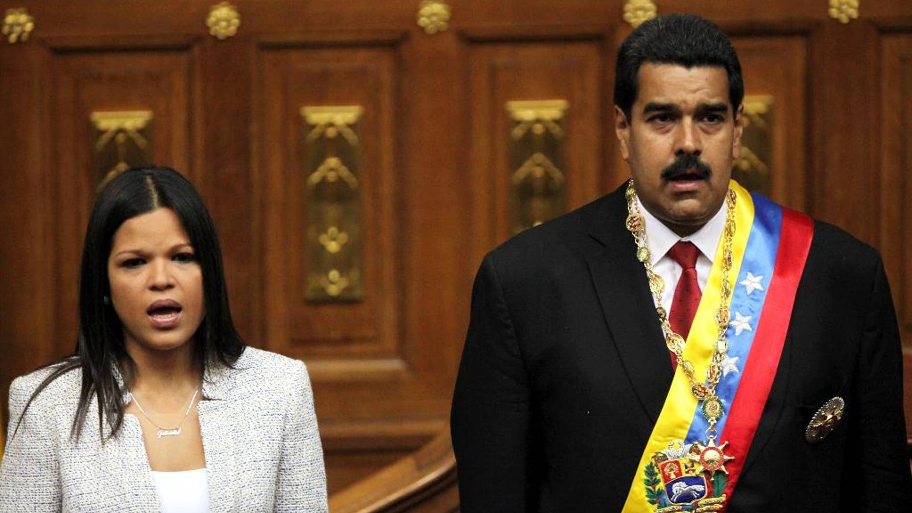 FILE - In this April 19, 2013 file photo, daughter of the late Hugo Chavez, Maria Gabriela Chavez and Venezuela's newly sworn-in President Nicolas Maduro, join in the singing of their national anthem in the National Assembly, in Caracas, Venezuela. In a July 23, 2014 closed-door meeting July at U.N. headquarters in New York, Venezuela quietly secured the backing of Latin America and the Caribbean to obtain a seat on the United Nations Security Council. Maria Gabriela Chavez is Venezuela’s alternate ambassador to the U.N. (AP Photo/Fernando Llano, File)