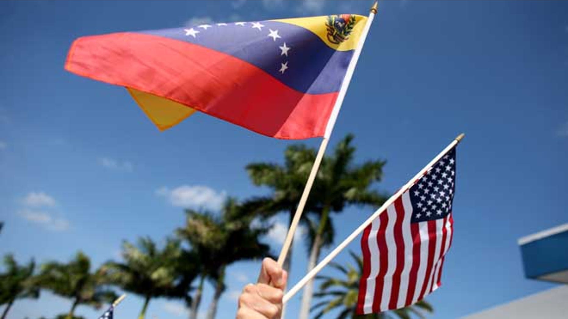 MIAMI, FL - MARCH 01: A protester holds a Venezuelan and American flag as she and other Venezuelans and their supporters show their support for the anti-government protests in Venezuela on March 1, 2014 in Miami, Florida. (Photo by Joe Raedle/Getty Images)